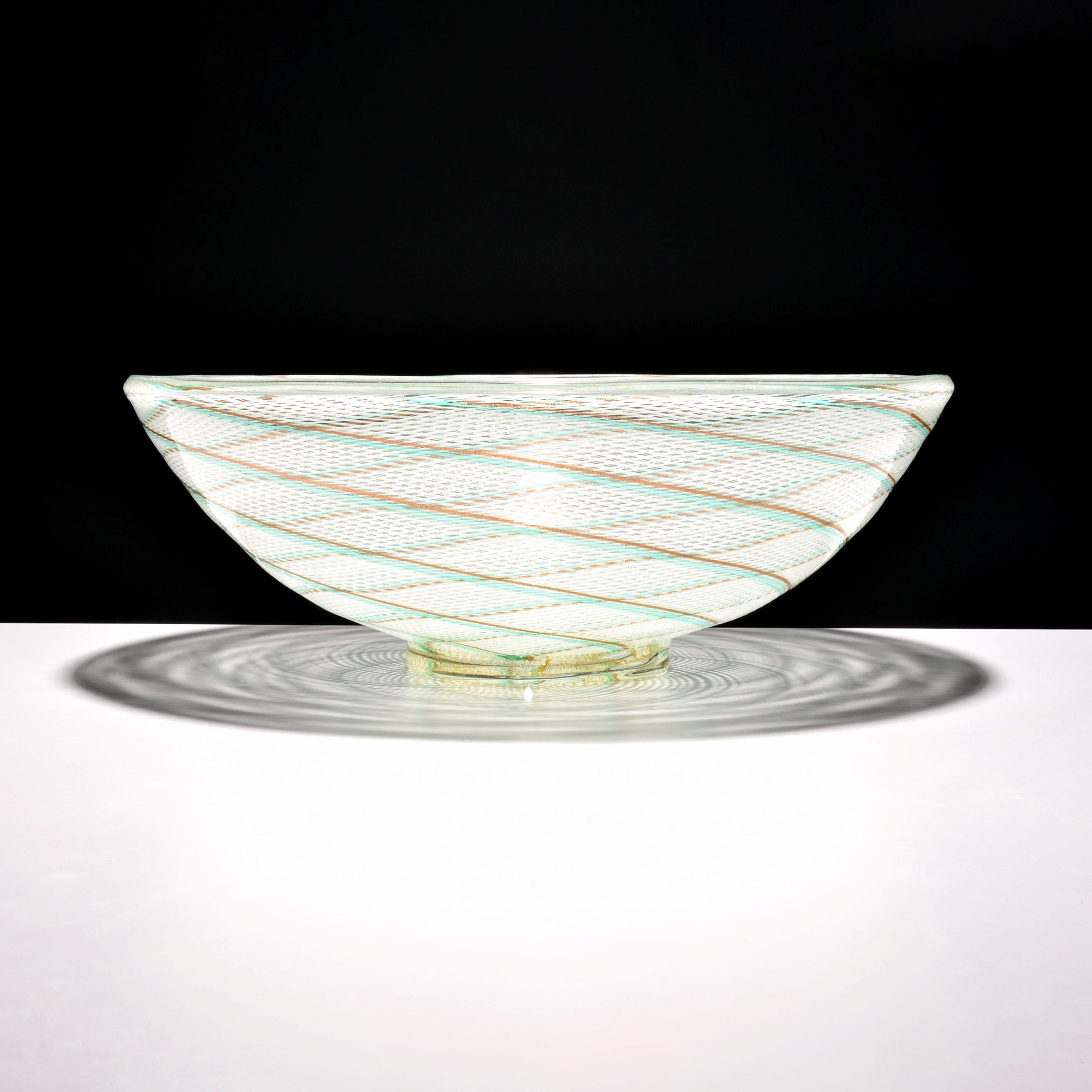 Artist/Designer: Dino Martens (Italian, 1894-1970)

Additional Information: Vessel has copper aventurine throughout.

Marking(s); notes: label

Country of origin; materials: Italy; glass

Dimensions: 6″h, 16″dia

Condition: good, no chips or cracks