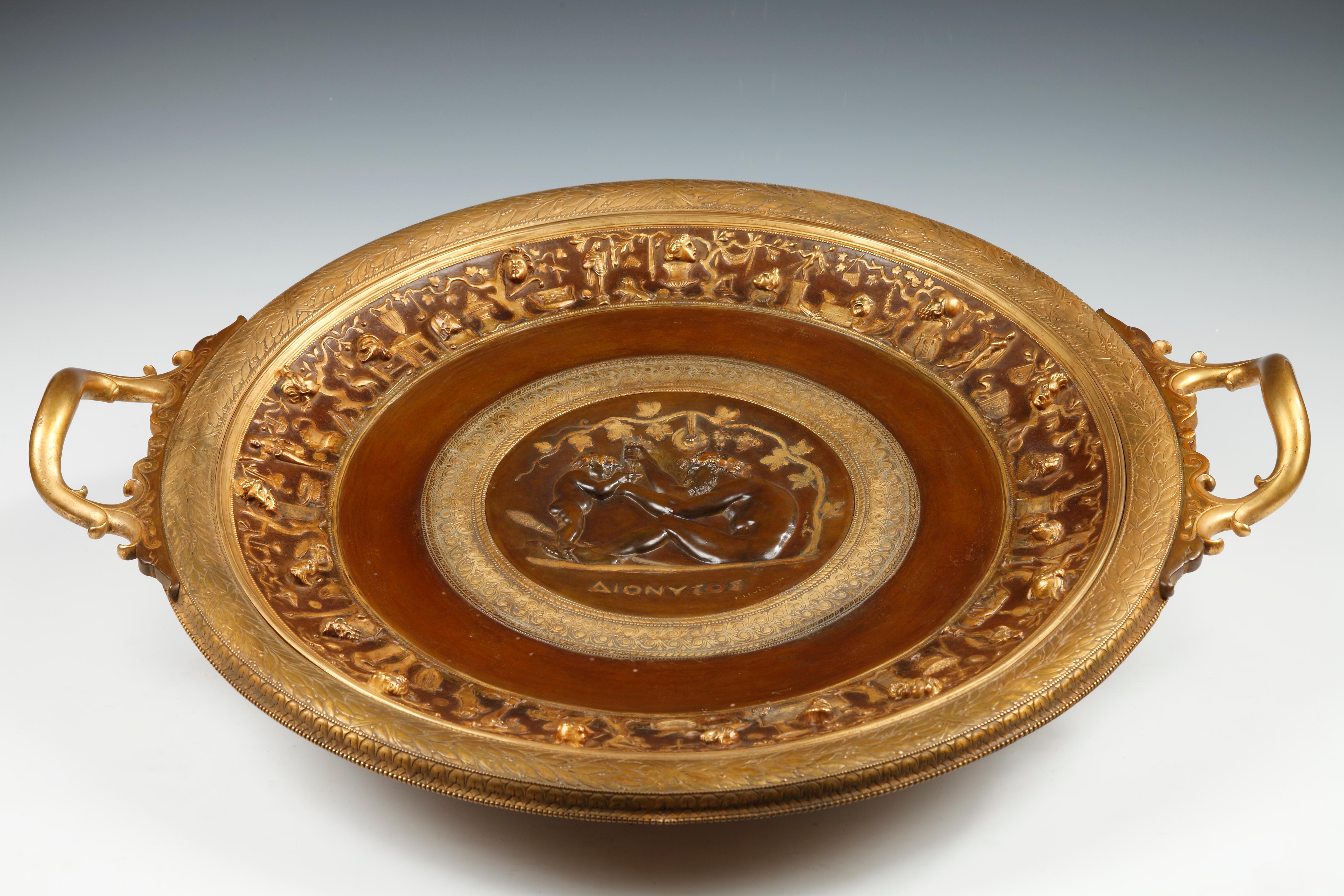 Superb large Greek-style display dish made with two patina bronze signed F. Levillain and F. Barbedienne. Decorated in the middle of a scene depicting an ancient man, a thyrsus in his feet (stick wrapped in ivy), pressing his hands a bunch of