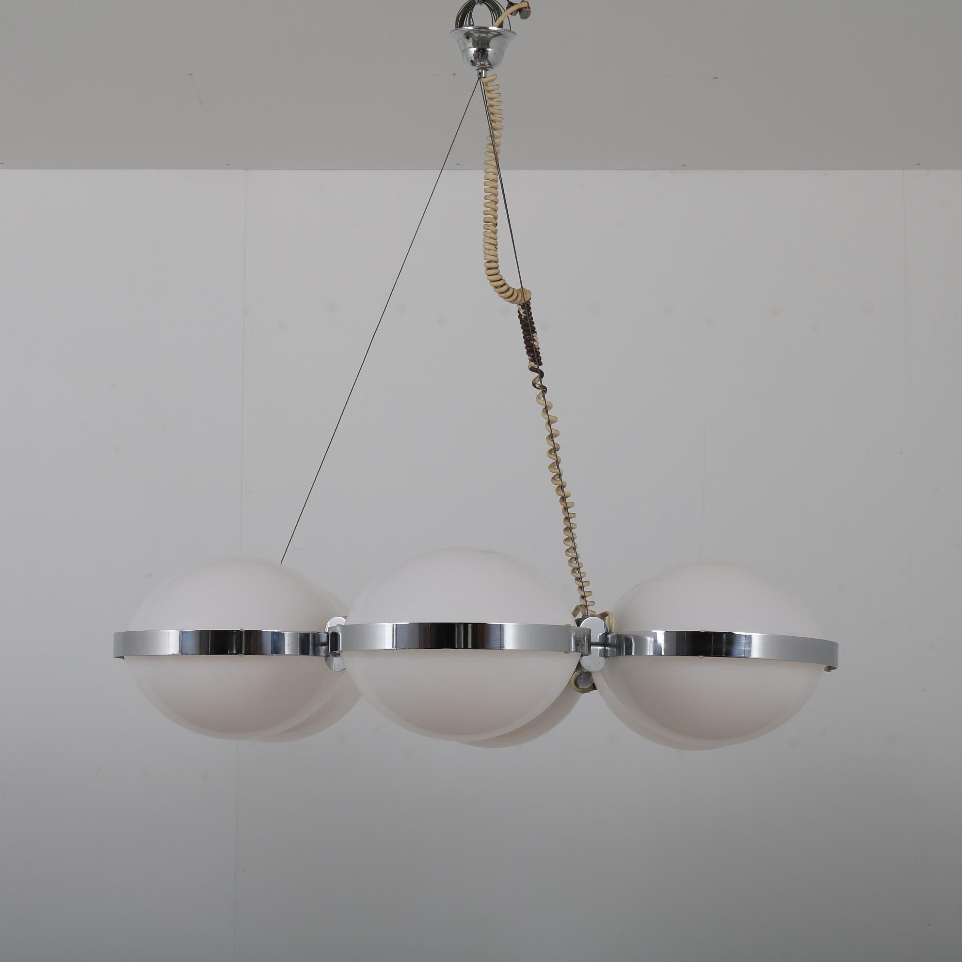 An eye-catching, large chandelier / hanging lamp manufactured by Vest Leuchten in Austria around 1960.

This is a beautiful Austrian lamp, made of high quality chrome plated metal holding six milk glass disks. There’s a light bulb within each disk