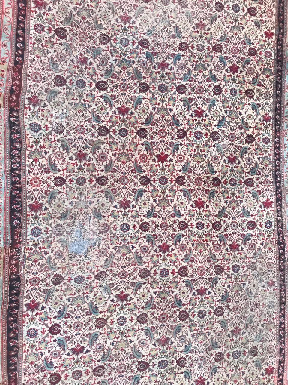 Beautiful and decorative antique Indian Agra rug with a white field and Herati design with red and green colors, accidents and damaged with old reparations. Entirely hand knotted with wool velvet on cotton foundation.
