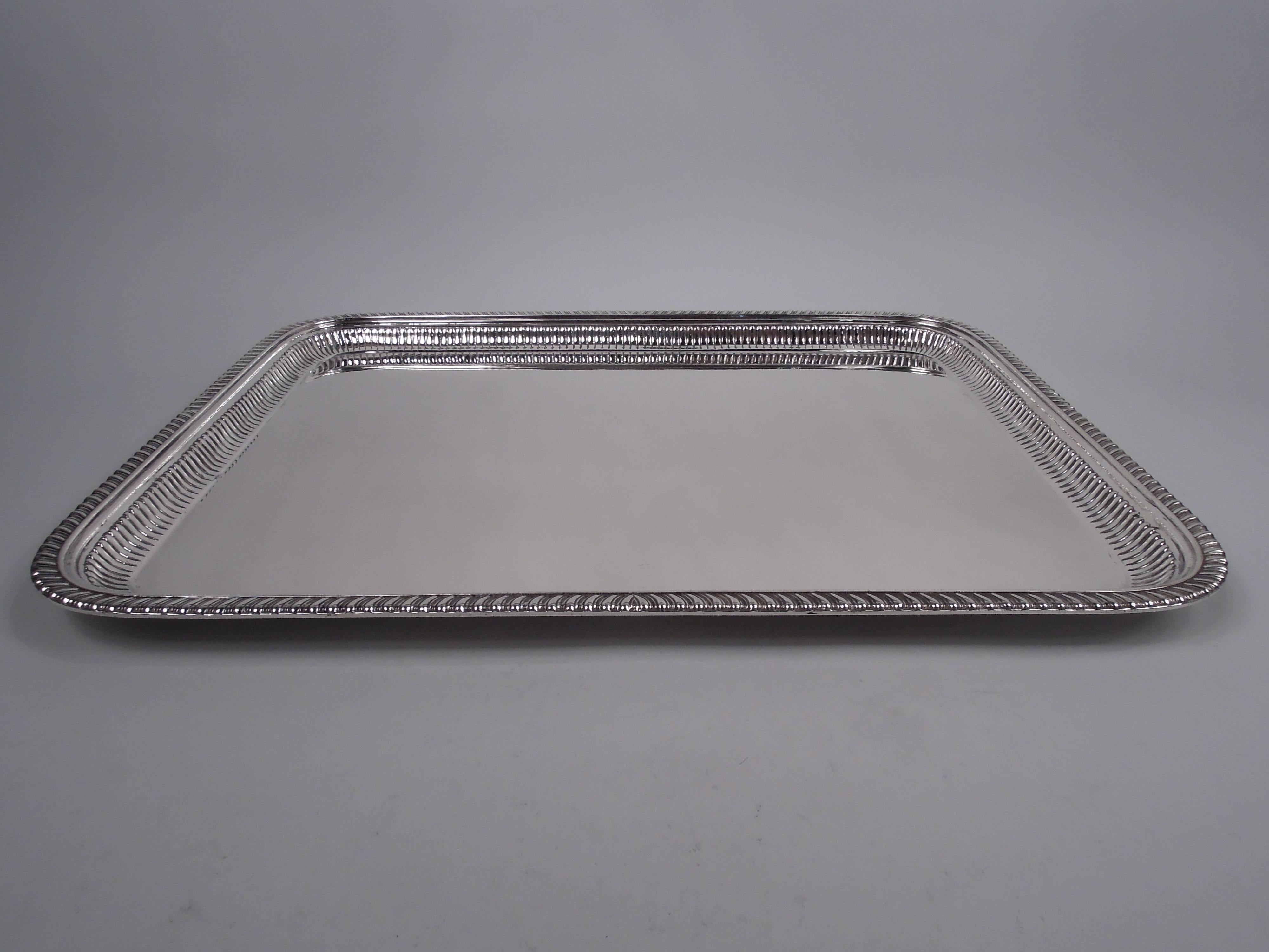 Large Victorian Classical sterling silver tray. Made by Dominick & Haff in New York in 1890. Rectangular with curved corners. Fluted sides and gadrooned rim. Stylistically restrained with nice heft. Fully marked including dated maker’s stamp,
