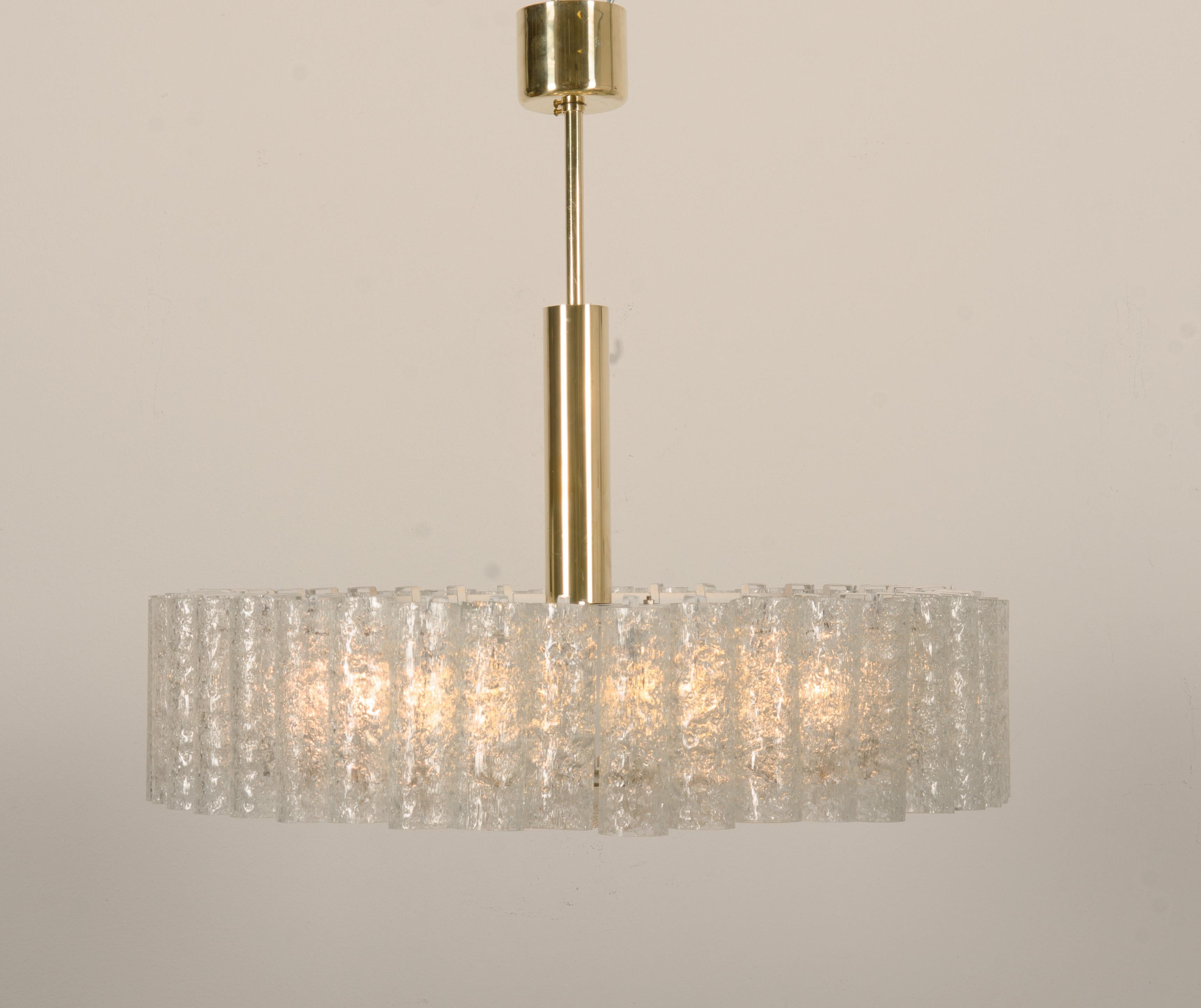 Exquisite chandelier with glass pirouettes encircling a brass plate with crackled glass diffuser.
Fitted with six E-27 bulbs. Designed by Doria in Germany in the 1960s.
2 pieces available, price per chandelier.