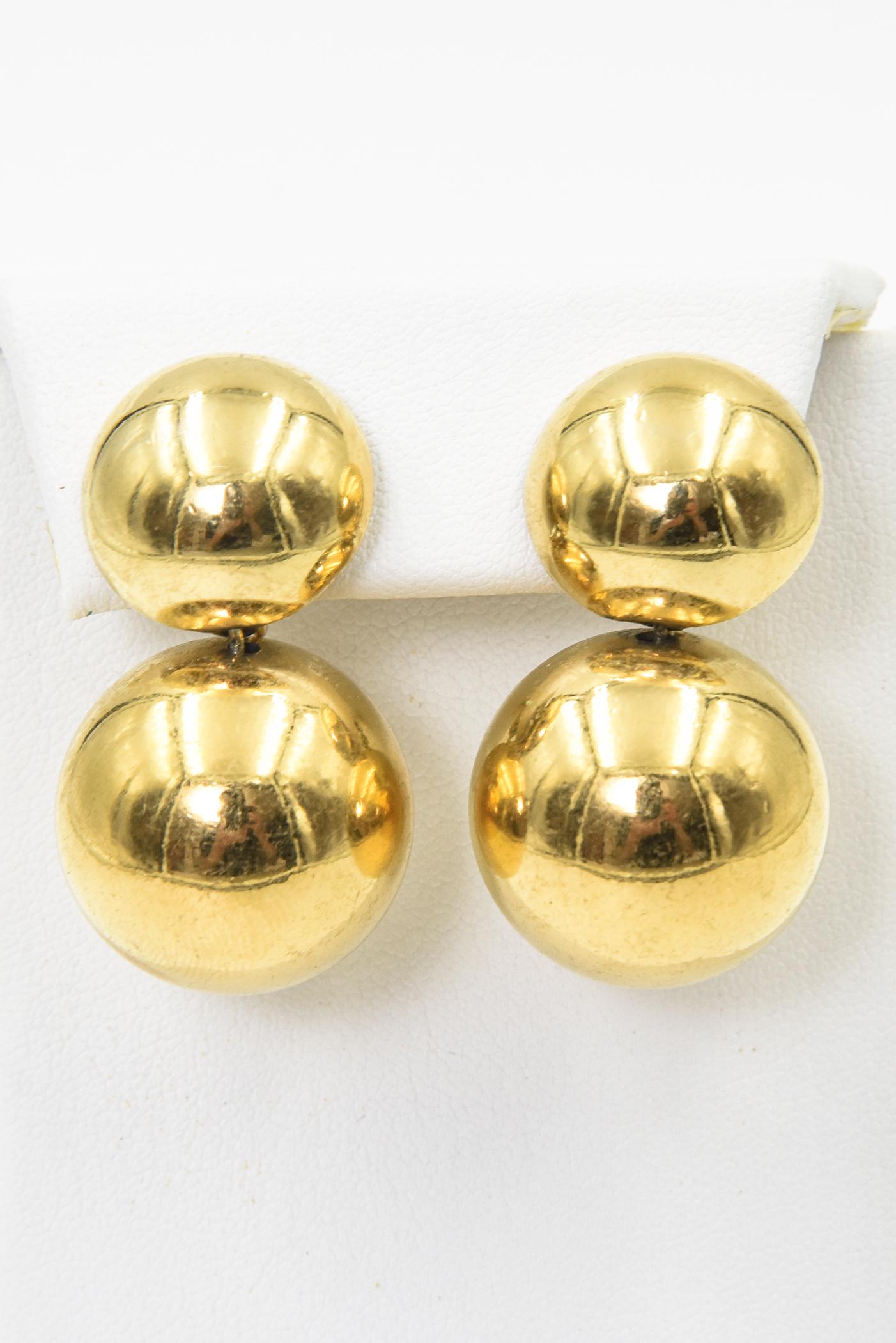 These fun late 20th century earrings feature an approximately 18mm button earring on top with a 25mm ball dangling from the bottom.  They have an adjustable clip on back so no piercing required.