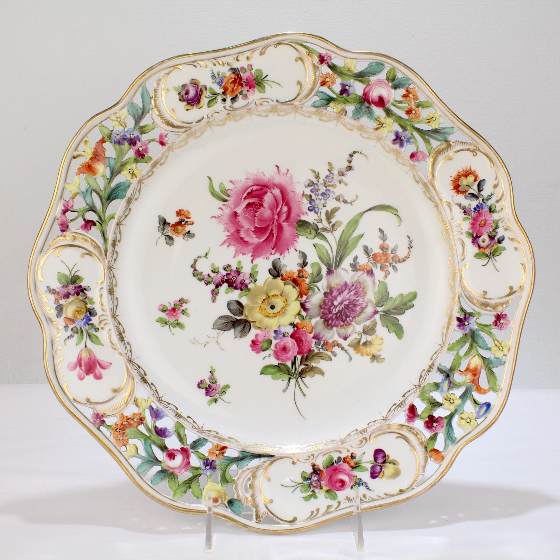 A fine large Dresden porcelain Charger by Potschnappel.

With a scalloped rim, a reticulated border with panels that have cartouches of flower garlands, and a center painted with a very large, finely hand painted spray of Deutsche Blumen
