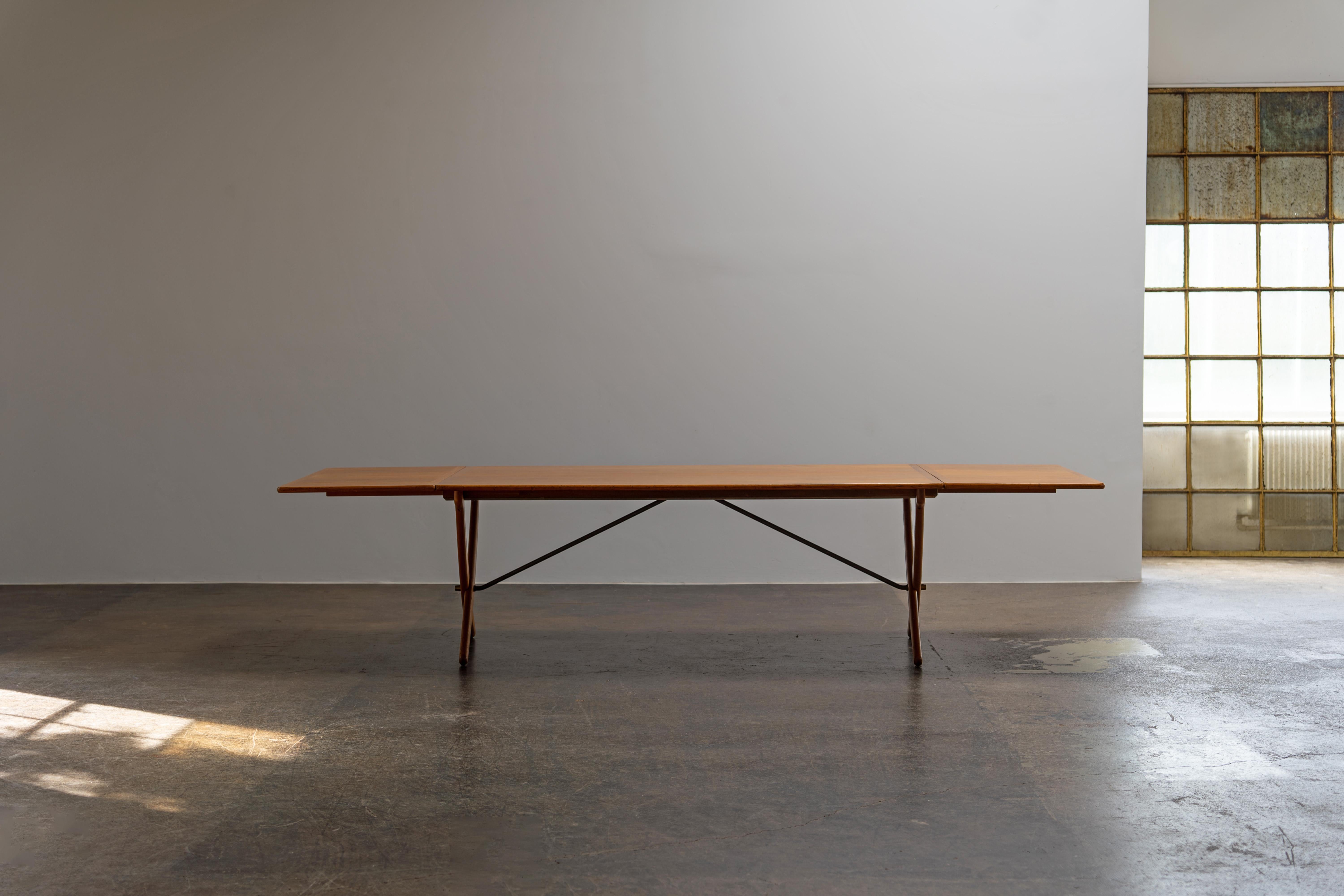 Designed in the 1950s and crafted by Andreas Tuck in the 1960s, this collector's piece stands out with its elegant teak tabletop and sturdy oak frame. The iconic curved sabre legs and stylish brass stretchers add both stability and a touch of