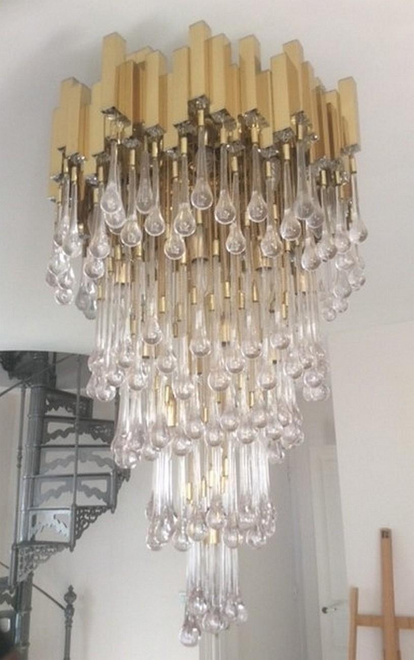 Beautiful large chandelier by Lumica, Barcelona, Spain, 1970 period.
It consists of a square brass tubes structure with chrome tips, which are hung full glass drops with small chains in gilded metal.
230 glass drops. Twenty light bulbs. It may