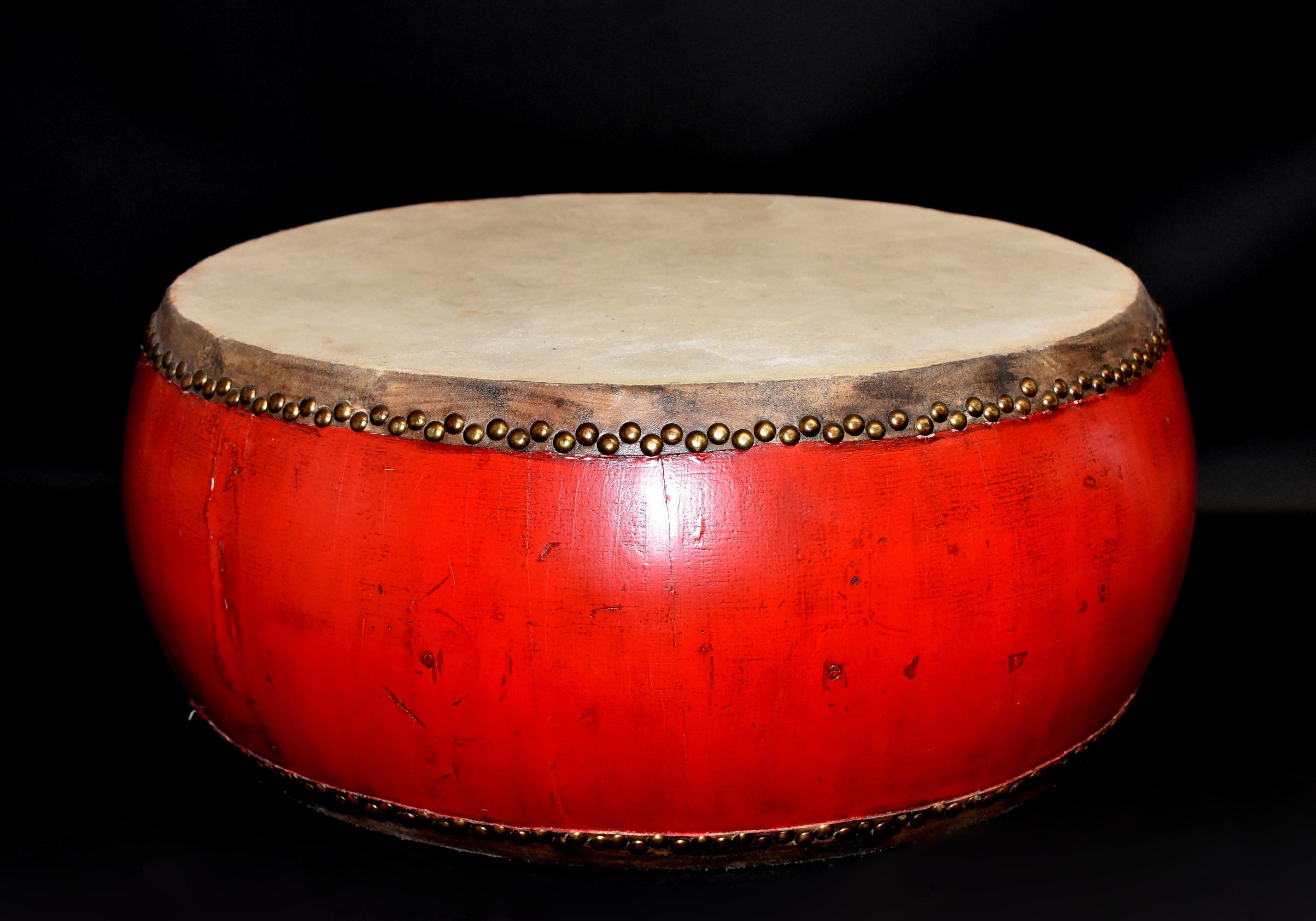 A beautiful red lacquered drum on solid wood base, covered in leather with brass nails. A highly unique piece that adds great interest to any interior, besides being fully function as a drum. Great condition, rare form.