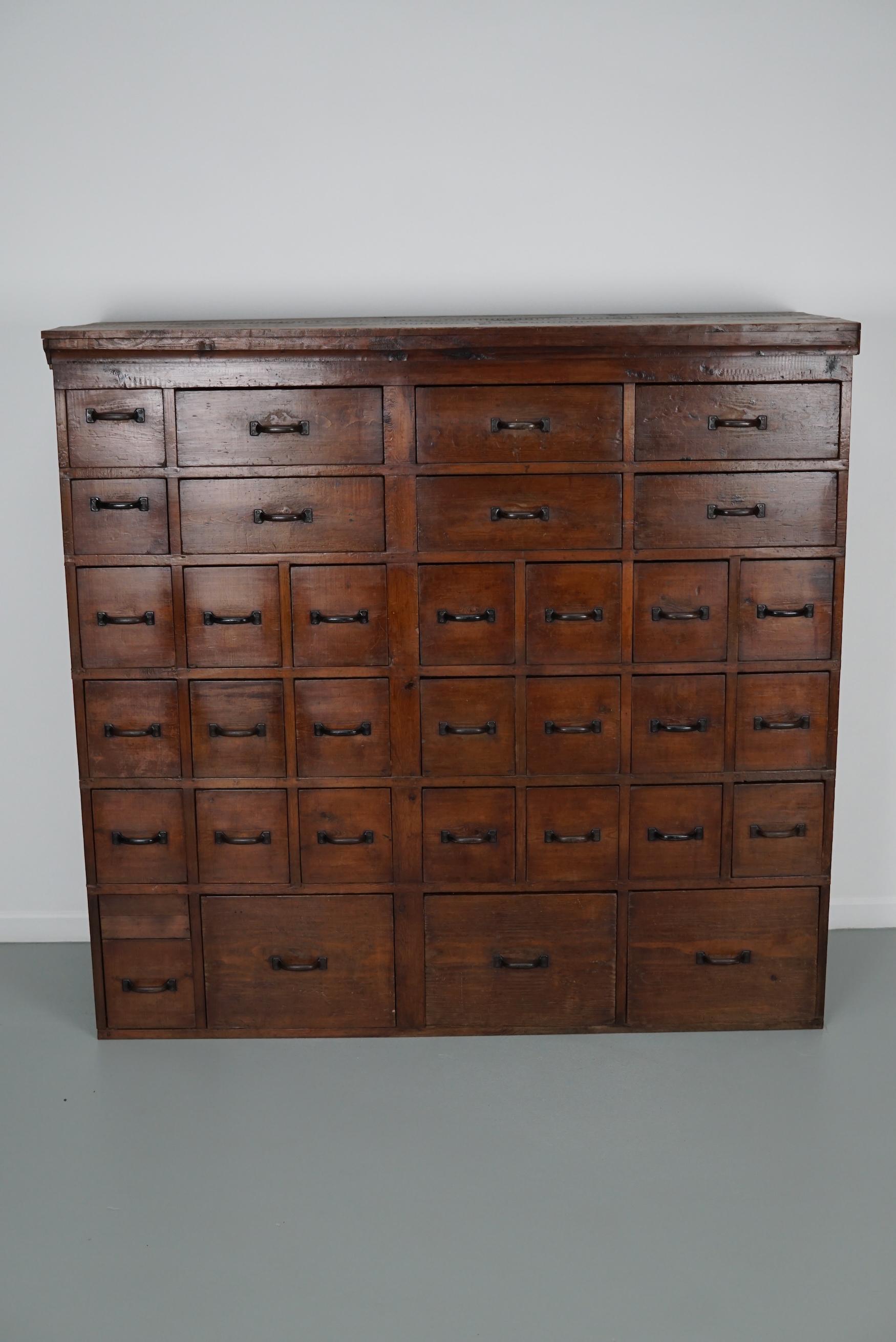 This workshop cabinet was made from pine in the Netherlands circa 1950. It features many drawers in different sizes with black metal handles. The interior dimensions of the drawers are: DWH 45 x 35 / 13.5 / 34 x 13 / 18 / 27 cm. The cabinet has