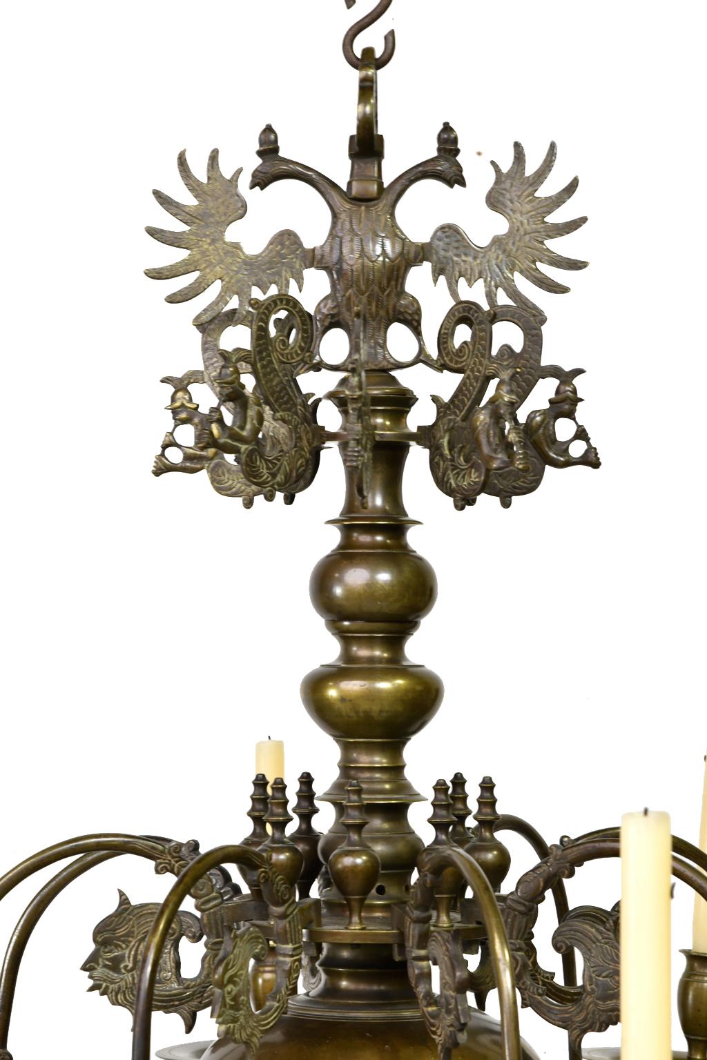 An exceptionally beautiful and large Baroque chandelier with candelabra from the low countries in Europe in cast bronze with eight removable arms and decorative, mythological motifs that include a double-headed eagle, dolphin-headed serpents and
