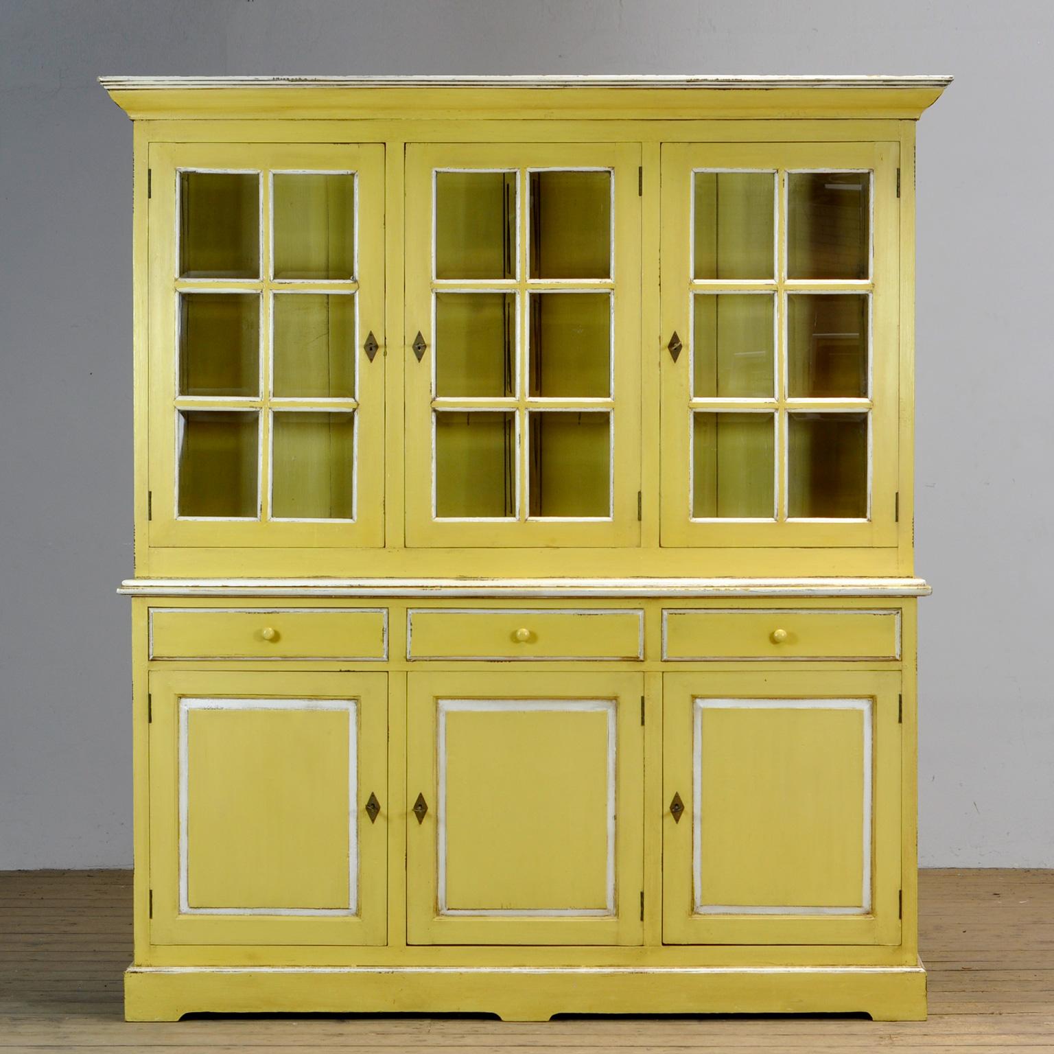 Large pine cupboard from the 1940s. With facet cut glass in the upper part. Two shelves in the upper part and one in the lower part. With properly working locks/keys. The cabinet consists of two parts.
This color yellow was previously widely used in