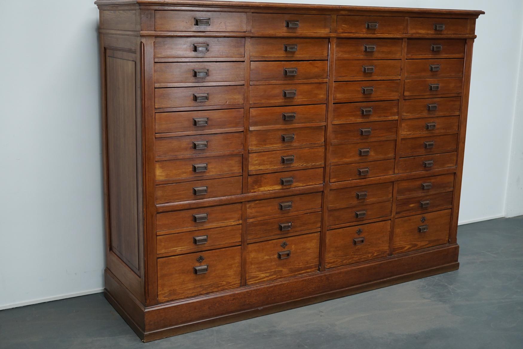 This apothecary cabinet of drawers was designed, circa 1920s in the Netherlands. The piece is made from pitch pine and features 44 drawers with brass hardware. The interior dimensions of the drawers are: D 48 x W 42.5 x H 7.5 and 20.5 cm.
 