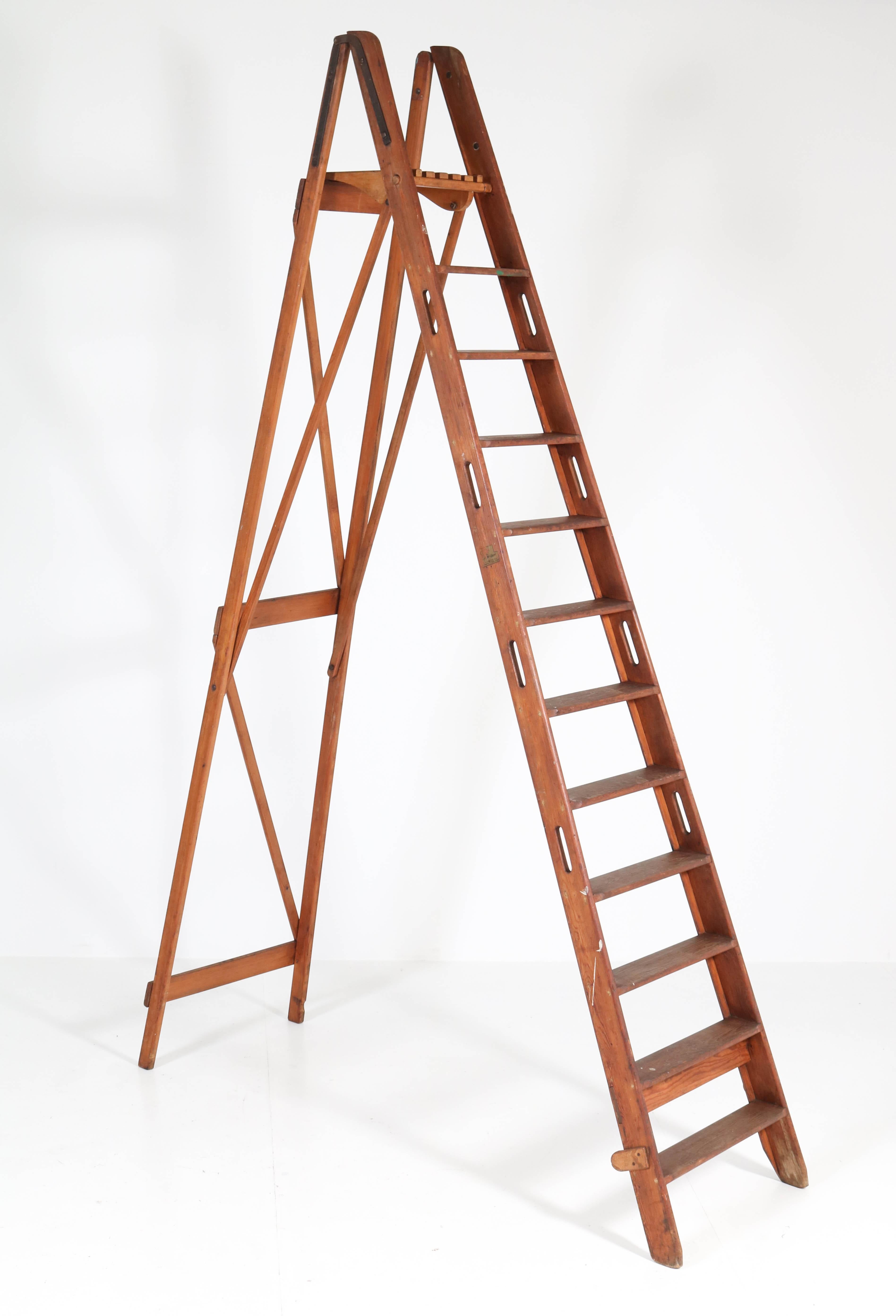 Stunning and large folding painting or library ladder.
Marked with manufacturers label de Krijger Amsterdam.
This version is rare because the ladder has eleven steps!
Solid pitch-pine.
This ladder is sturdy for use in a library or for use as