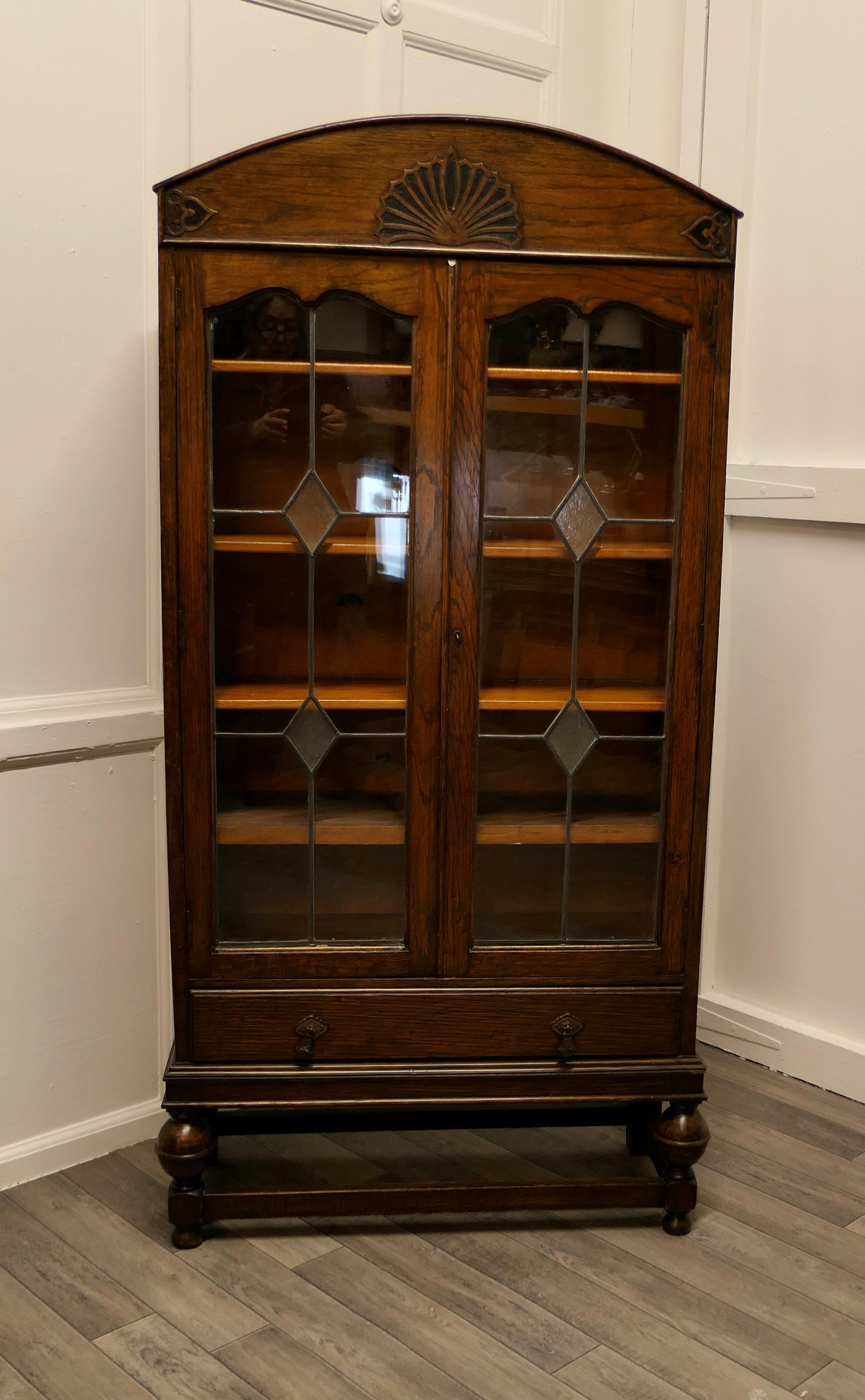 Large Dutch style art deco oak 2 door glazed bookcase.

The bookcase has 5 shelves, these have been fixed on wooden blocks for added strength. The top of the bookcase is domed in the dutch style with a some applied decoration, the doors are made
