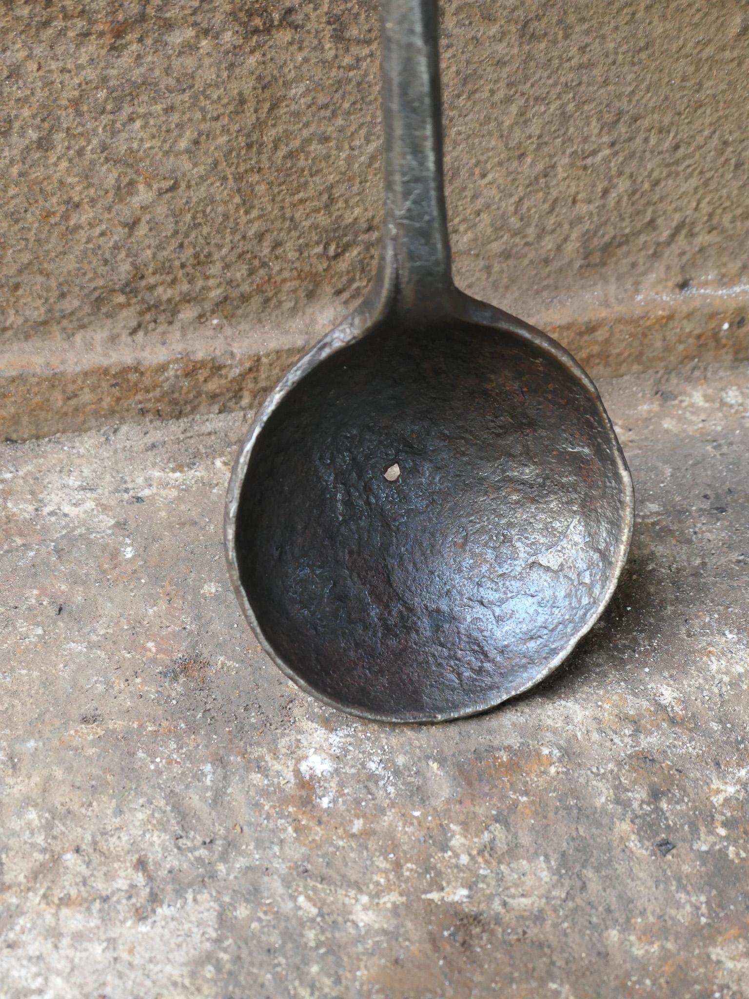 Bascule de cheminée en fer forgé de style Louis XIV du XVIIe siècle. L'arrosoir était utilisé pour répandre le jus sur les aliments pendant la cuisson.