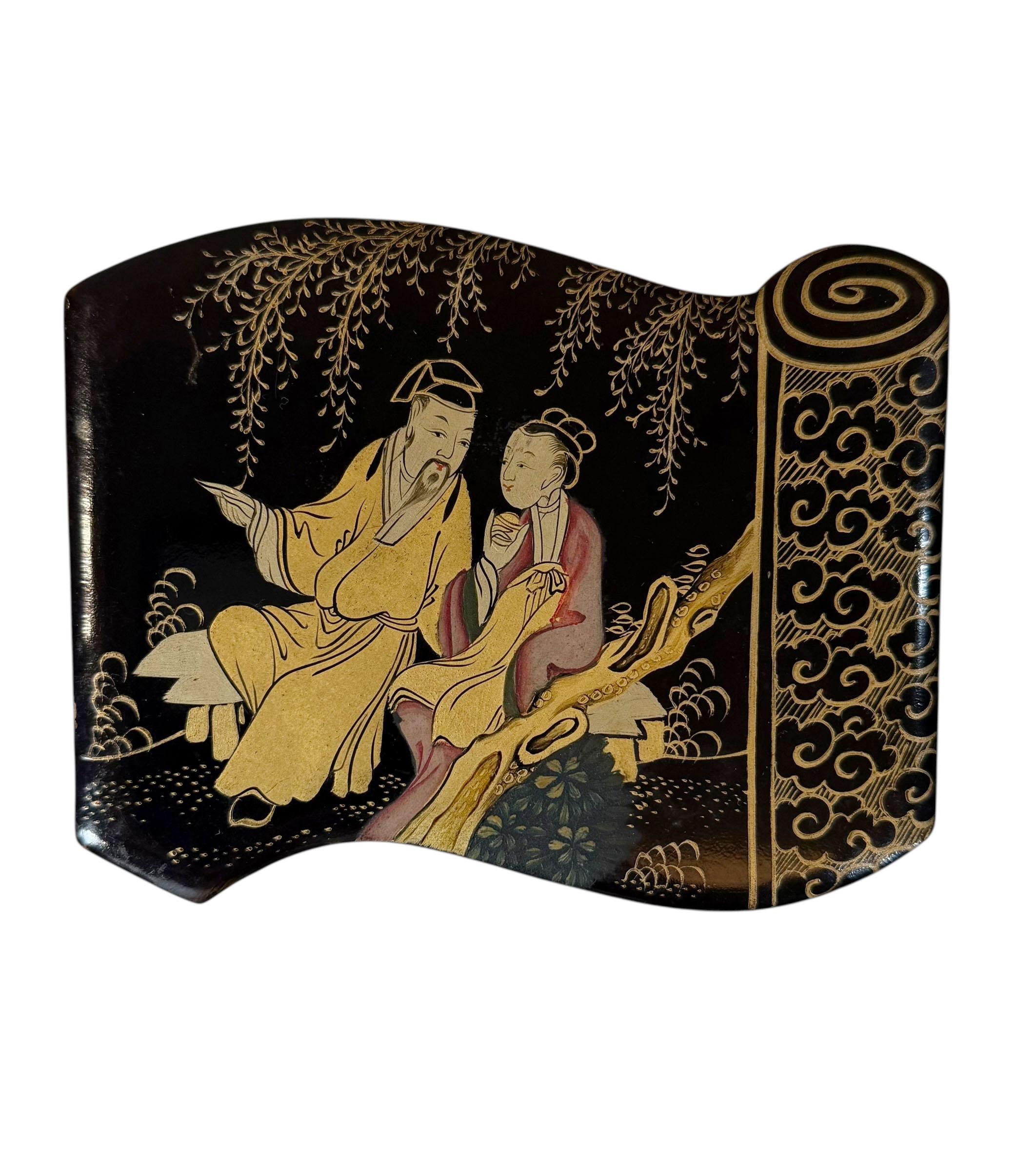 A large Chinese black lacquer work box dating from approximately 1800–1820. Shaped like a traditional scroll, it features a beautifully painted scene of an emperor with his maiden, rendered with rich detail and characteristic early Qing-period