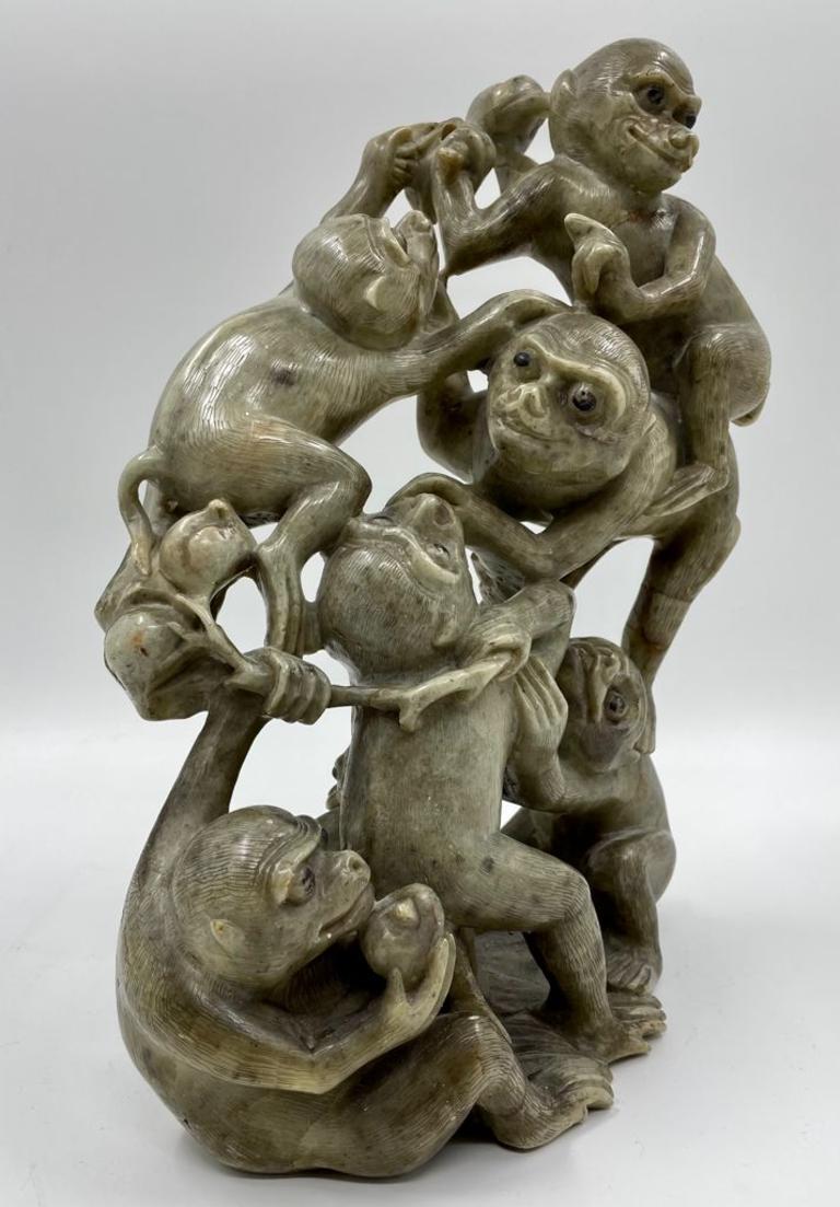 A rare large Chinese soapstone monkey group sculpture dating to the early 19th century, featuring seven intricately detailed monkeys scrambling over one another to reach a peach. The fur is finely engraved, and the eyes are highlighted in black,
