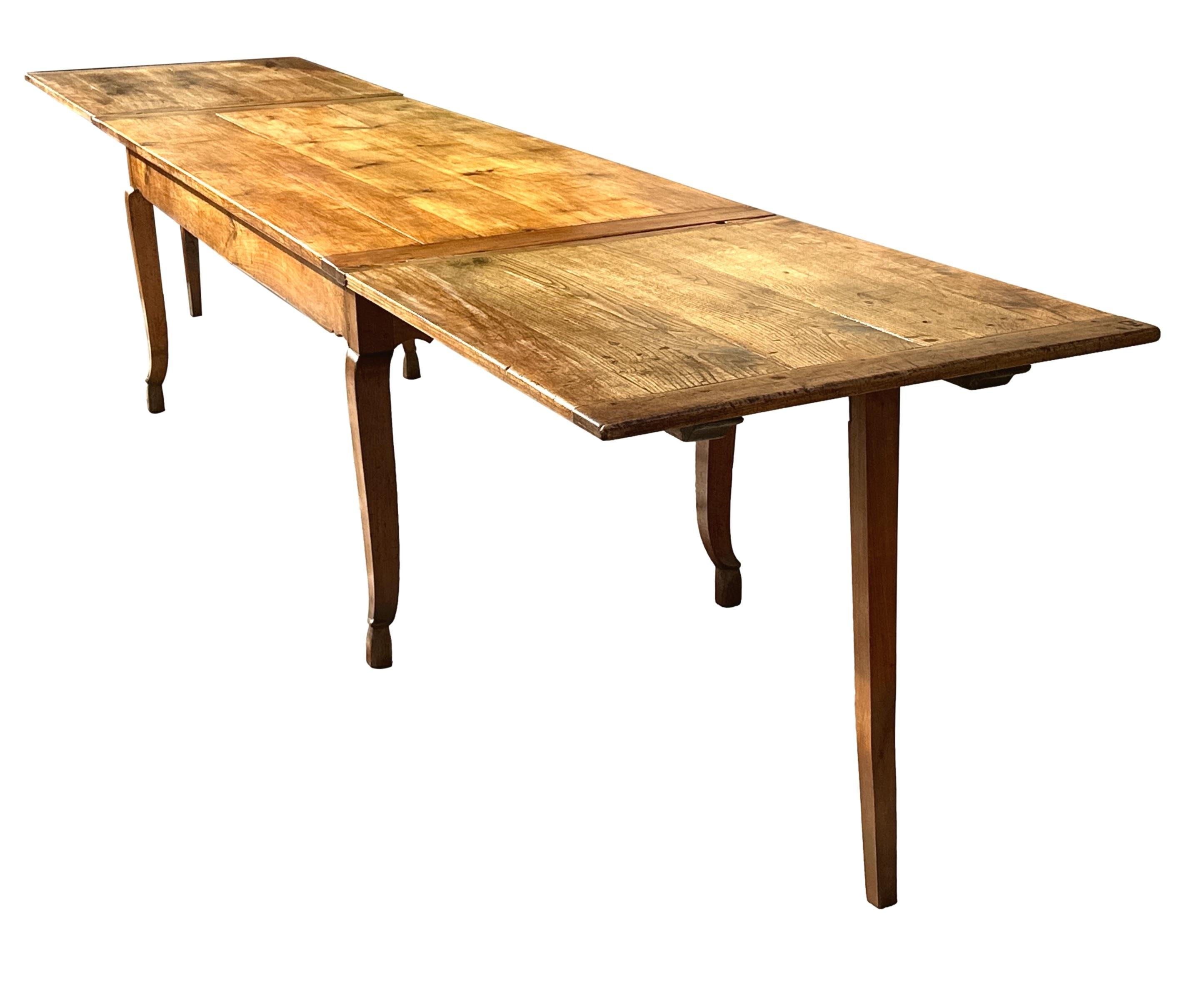 An Extremely Rare And Very Attractive, Good Quality, Early 19th Century French Cherry Wood & Chestnut Extending Farmhouse Kitchen Dining Table, The Well Figured Rectangular Top With Double Drawleaf Ends To Comfortably Seat 16 People, Raised Above