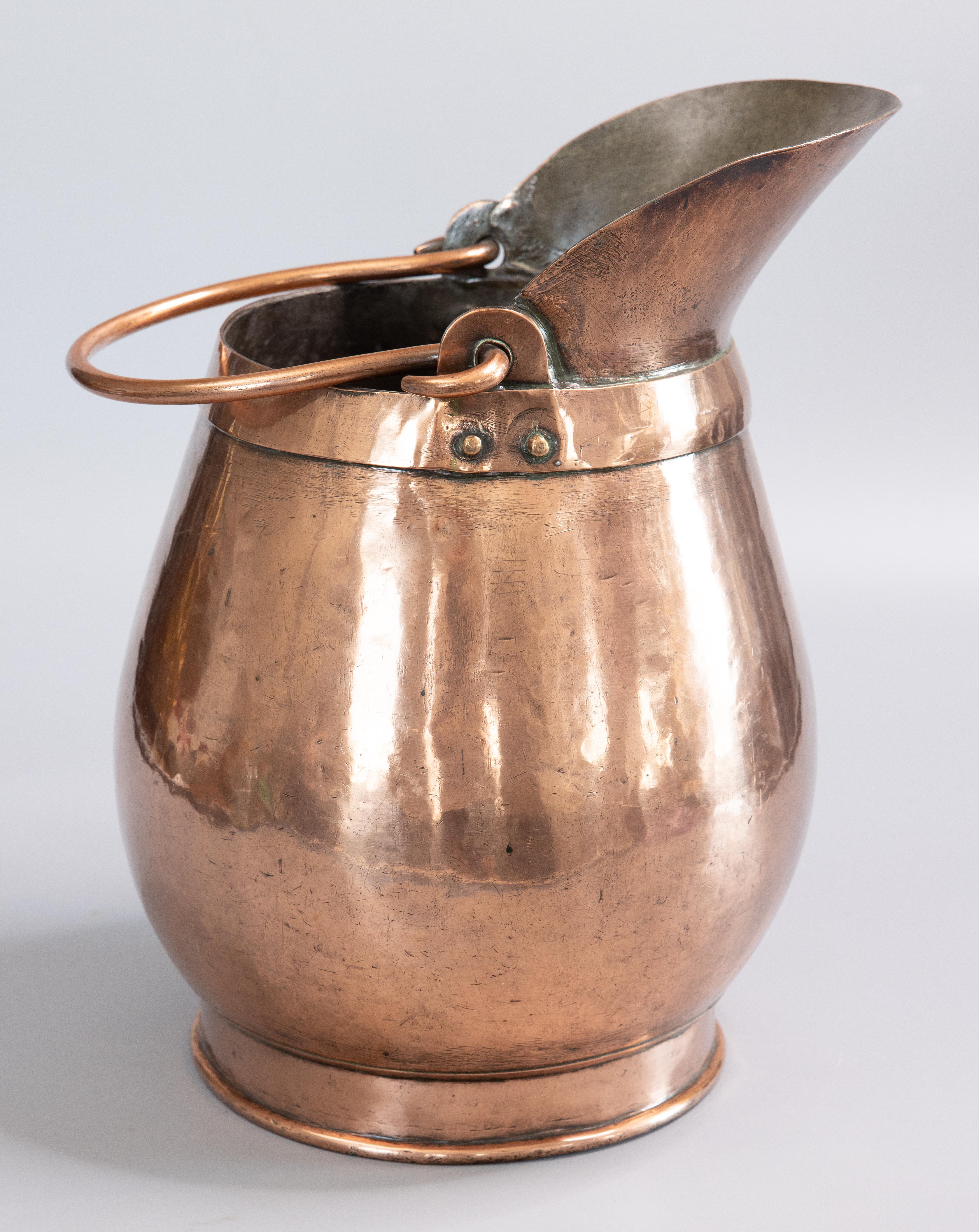 A superb large early 19th century French hand-hammered copper pitcher or jug. This gorgeous jug is solid and heavy weighing over 11 lbs, hand forged with copper rivets, dovetail seam, and a lovely swing handle. It has a beautiful patina and is in