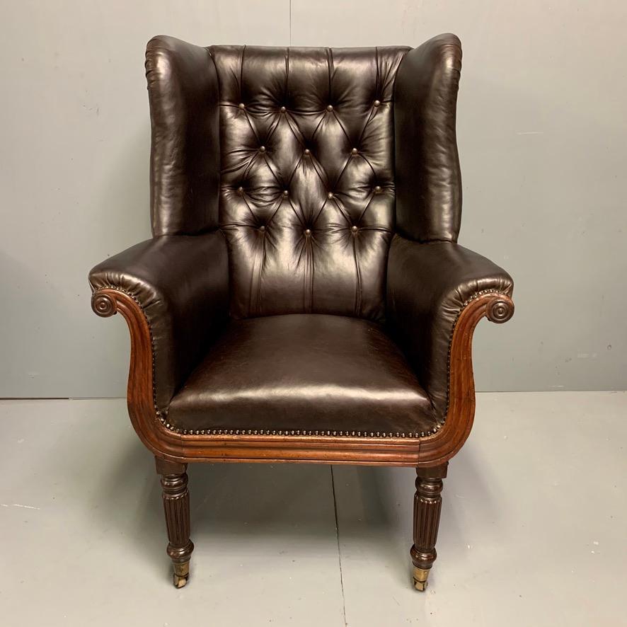 A generously proportioned Regency buttoned wing armchair, circa 1820 and in super condition.
Fabulous Regency curves to the carved mahogany frame and reeded legs on its original brass castors.
The leather is in very good order and this is a very