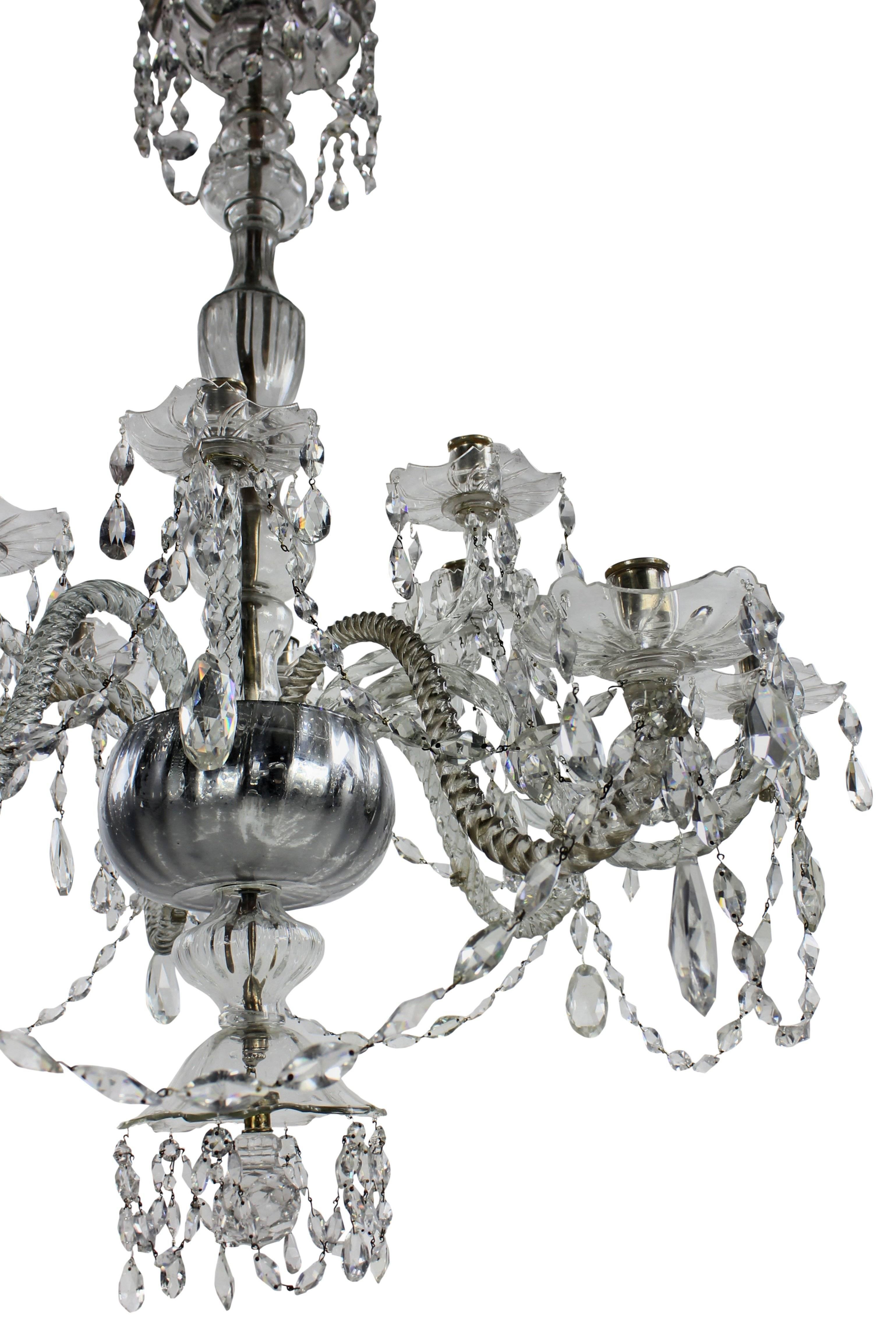 An early 19th century cut and blown glass Venetian chandelier of large proportions. With barley twist arms, molded fluted drip pans, baluster, swags and lemon cut drops. With canopy and silvered receiver dish. With six down-swept arms and six