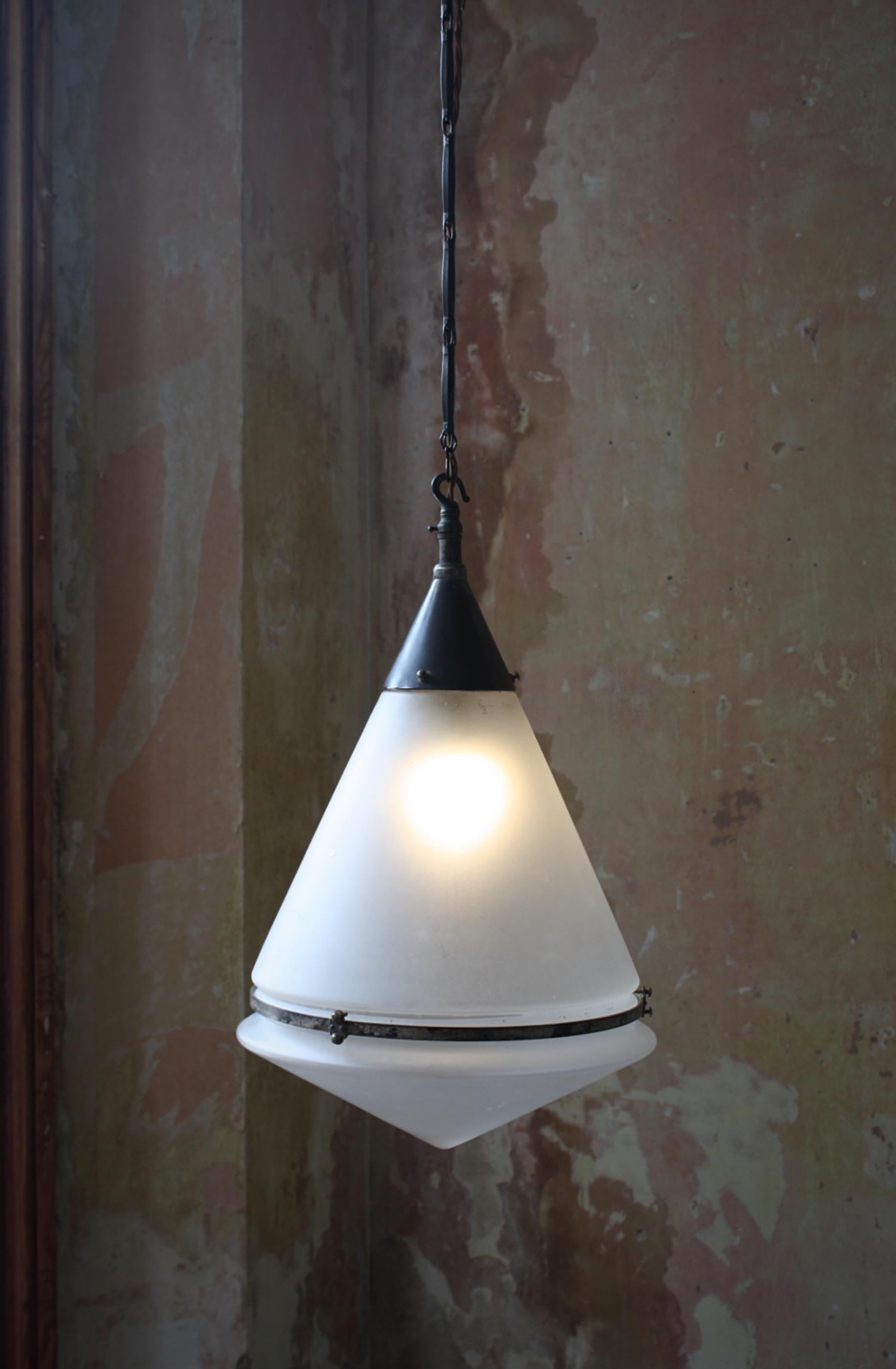 A rare and complete Peter Behrens conical pendant, with its original spun brass gallery central band and ceiling mount.

The lantern also has its factory issue pressed brass decorative chain that conceales the flex and a much large length than