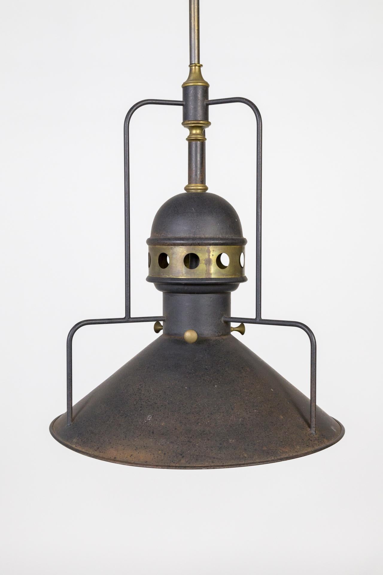 A large, unique, mixed metal light in dark bonze color with brass accents. The cogs were used to move the light along the work line and to raise and lower it. A striking example of industrial craftsmanship. American, circa 1905. Measures: 17.75