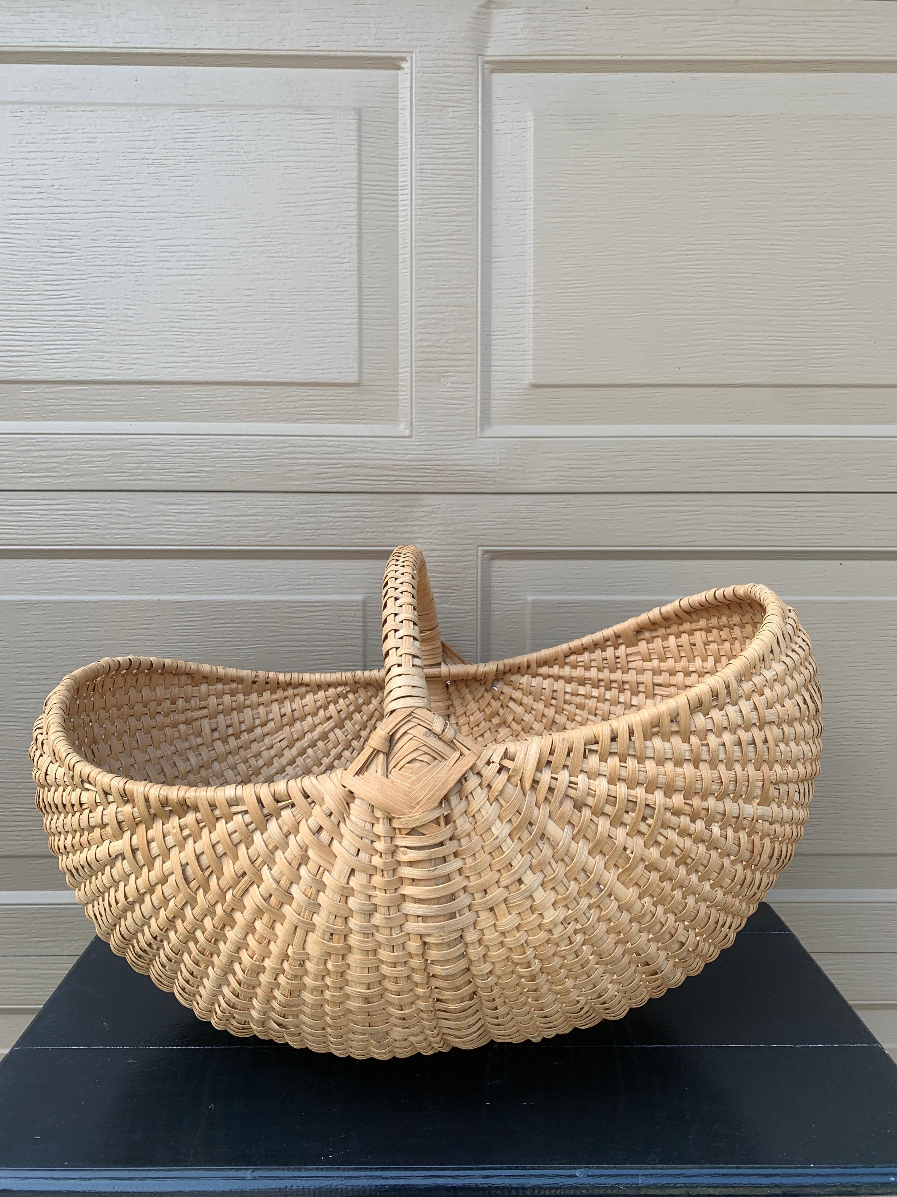 A large American splint oak gathering basket with woven twig handle. The charming basket has a tight weave and would be charming as a decorative or functional piece.

USA, Early 20th Century

Measures: 23.5