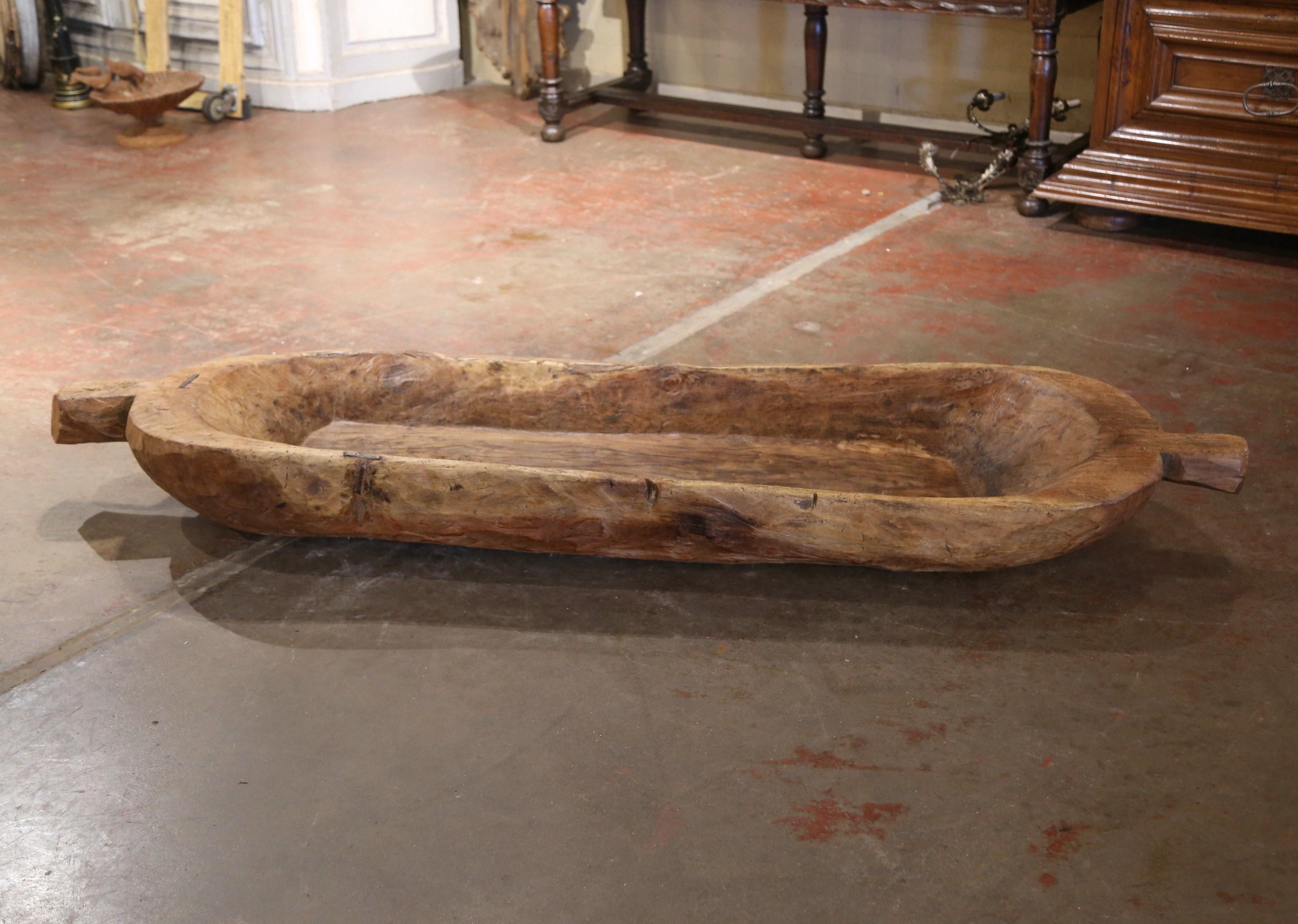 Decorate a dining room table or kitchen counter with this important antique dough bowl. Crafted in England circa 1920, and over seven feet long, the huge center piece is hand carved in one block of elm wood, and the worn and aged patina adds to its