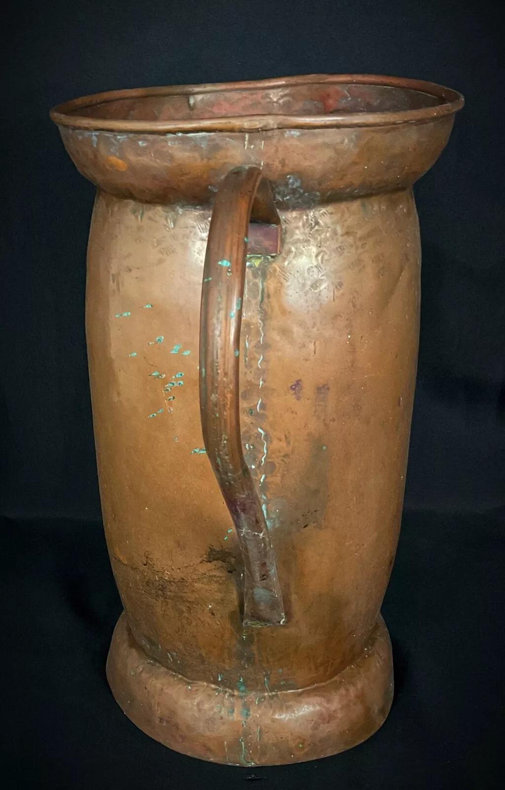 Questa grande brocca o portaombrelli in rame francese dell'inizio del XX secolo è un pezzo decorativo di grande effetto che aggiunge un tocco di fascino vintage a qualsiasi spazio. Con un'altezza di 43 cm e un diametro di 24,5 cm, questo oggetto