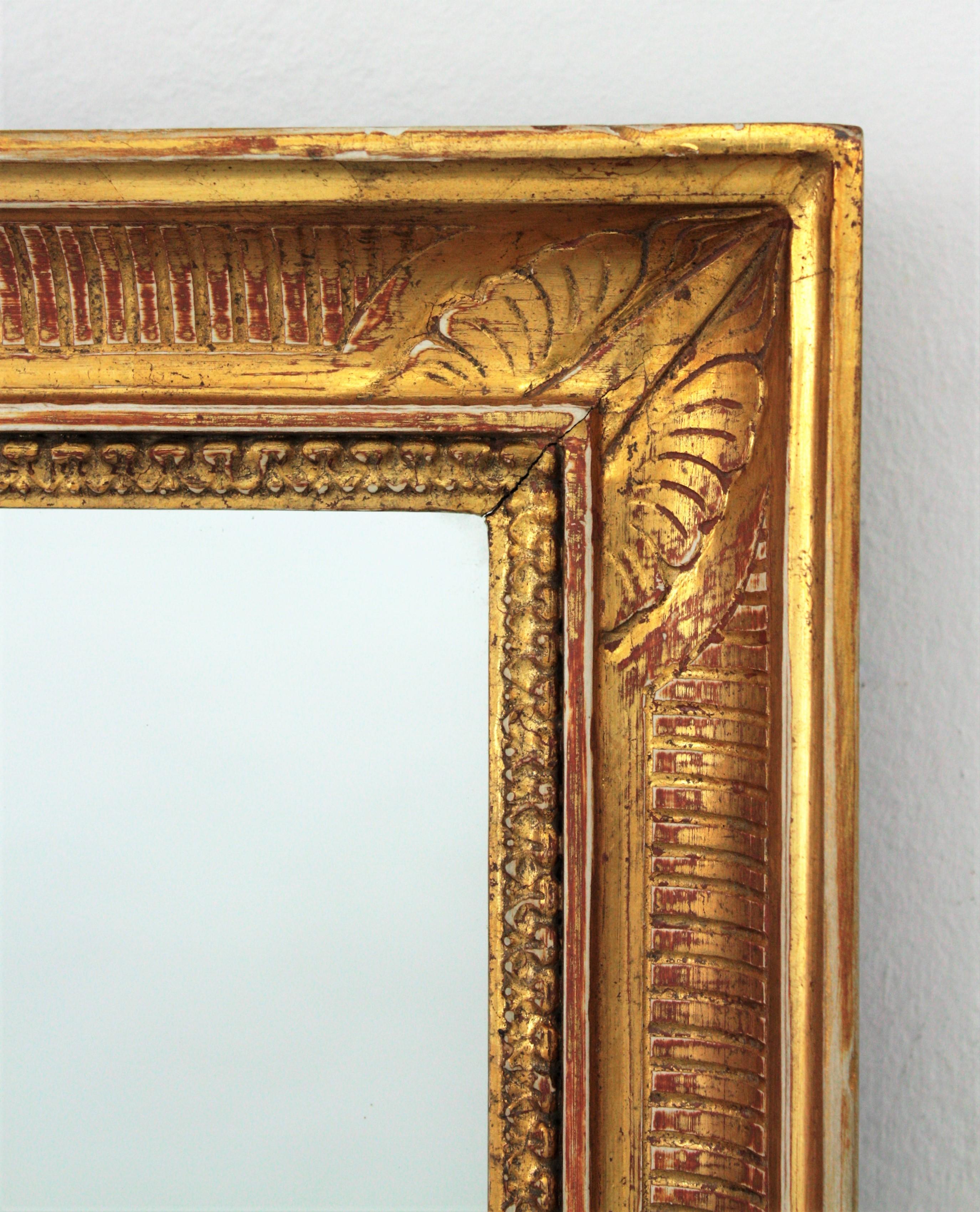 Large early 20th century giltwood Empire style mantel mirror or wall mirror, France, 1930s.
The original gold leaf gilded mirror frame is detailed with stripped molding and classical motifs at the corners. Excellent antique condition, wear to frame