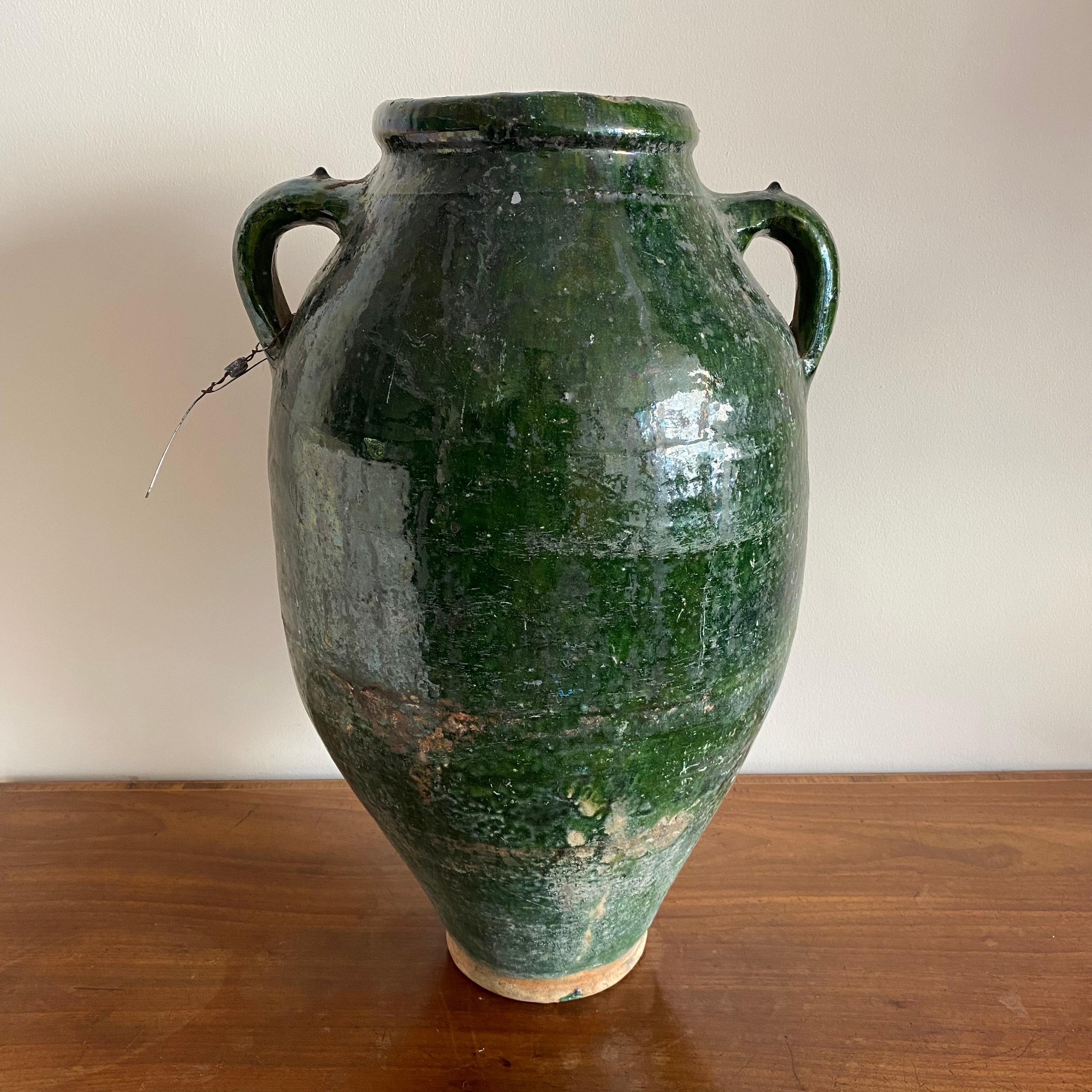 A very large French urn shaped pot with green glaze and 2 handles. Retaining its original lead seal.

Measures: Height: 48cm

Width: 28cm

Depth: 27cm.