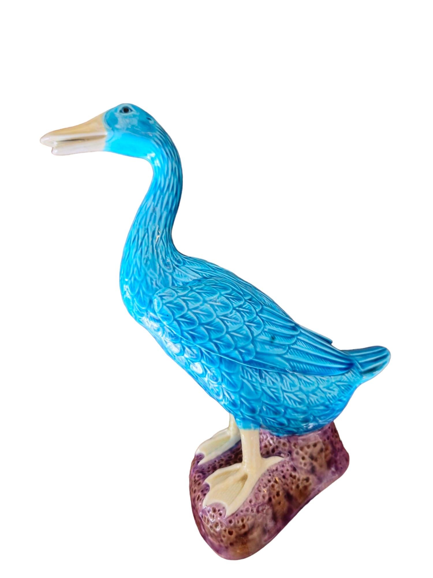 Siehe eine prächtige große glasierte keramische blaue Ente des frühen 20. Jahrhunderts mit einem königlichen lila Sockel. Dieses exquisite vogelkundliche Meisterwerk verkörpert die Eleganz vergangener Epochen und zeichnet sich durch sorgfältige