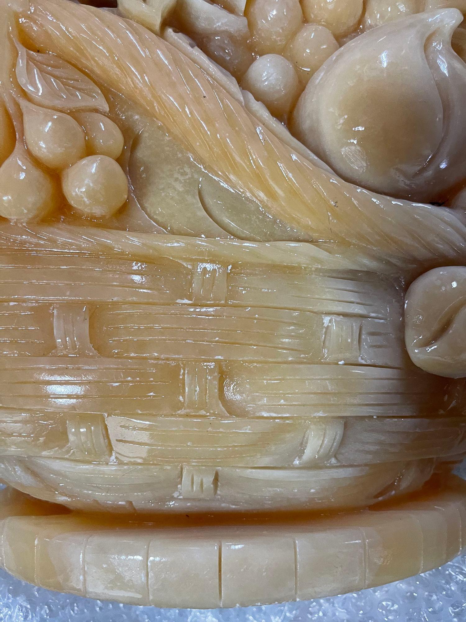 Exquise sculpture en onyx doré sculptée à la main, conçue de manière complexe en forme de panier débordant de fleurs délicates. Chaque pièce met en valeur la beauté naturelle de la pierre, avec de riches teintes dorées qui scintillent et accrochent