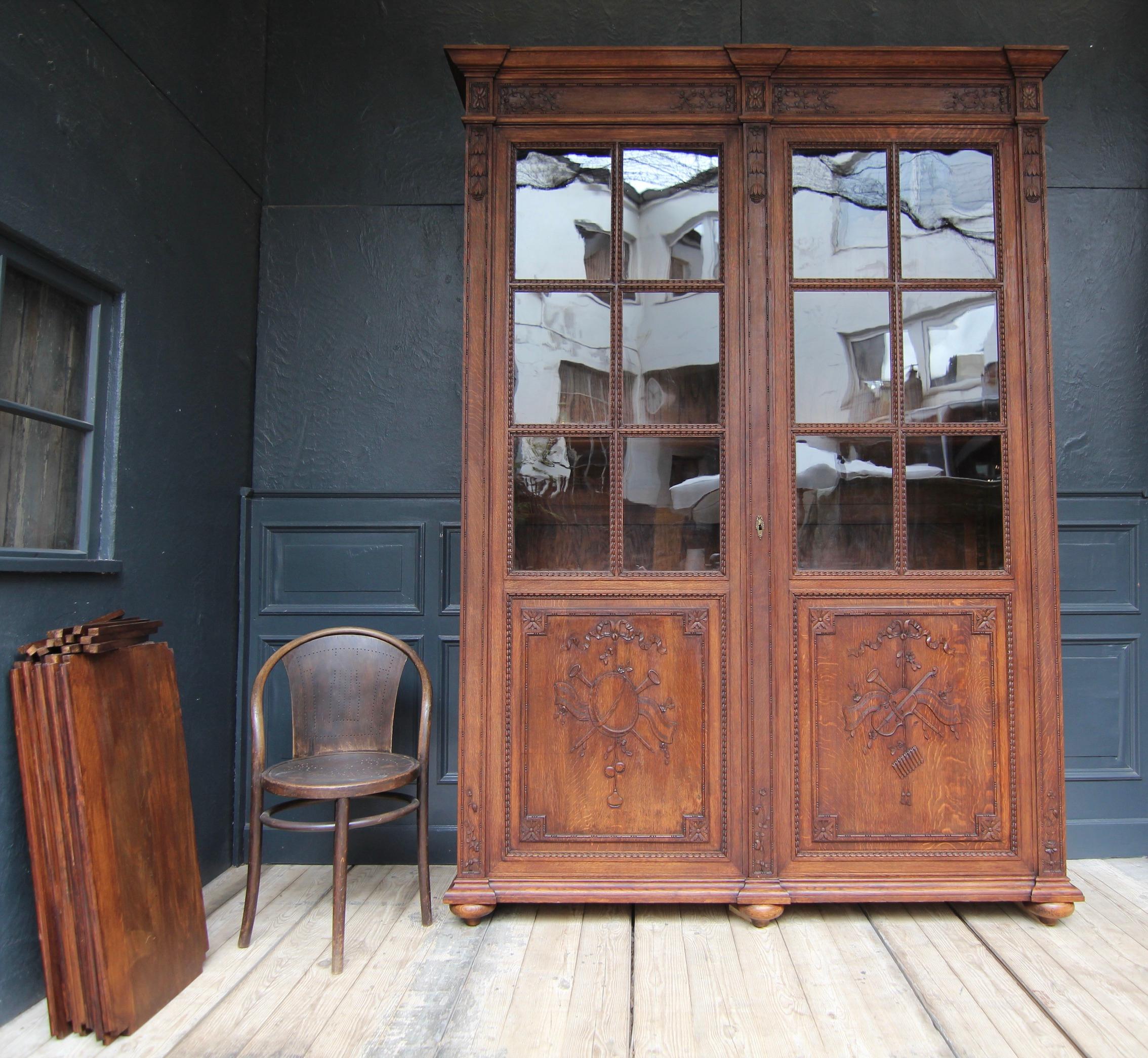 Bookcase or library in the Louis XVI style from around 1900. Solidly made of oak wood, with floral and ornamental carving.

Extraordinarily high corpus, coffered at the sides, with cranked and profiled base and cornice, carved pilasters and 2 large