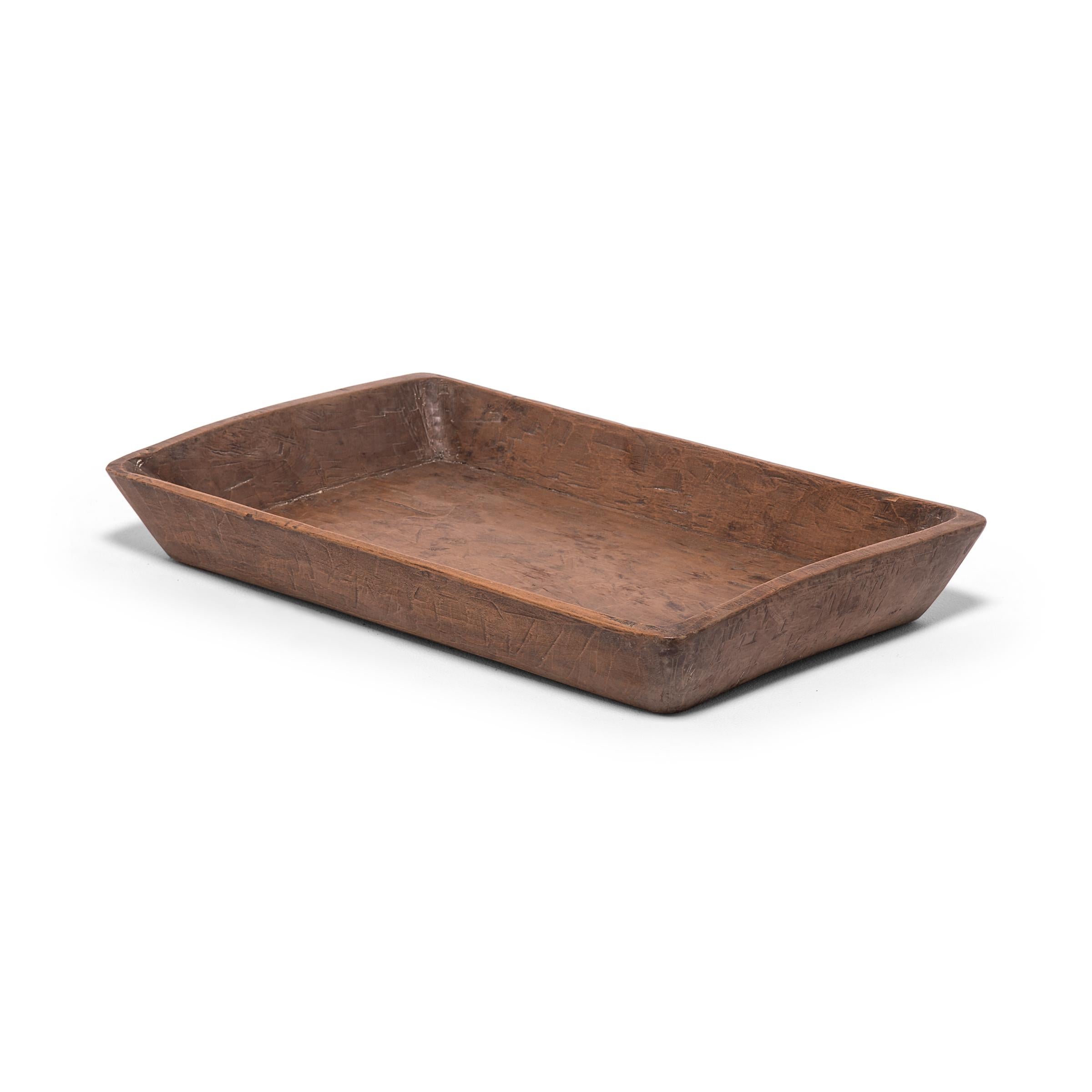 Carved from pine, this hundred-year-old tray made in northern China charms with its rusticity and simple shape. Marked with use and distinguished by the natural grain and knots of wood, the tray brings its timeless appeal to modern interiors as a