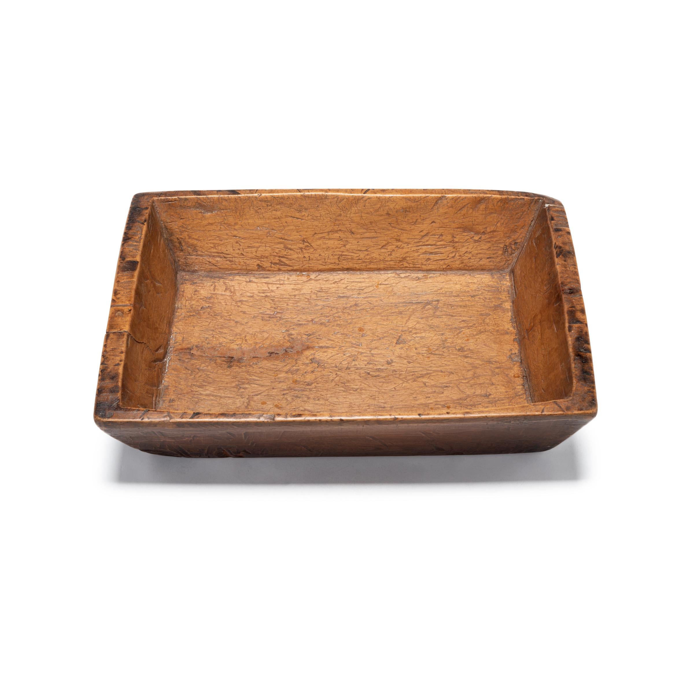 Carved from pine, this hundred-year-old tray made in northern China charms with its rustic character and simple shape. Marked with use and distinguished by the natural grain and knots of wood, the tray brings its timeless appeal to modern interiors