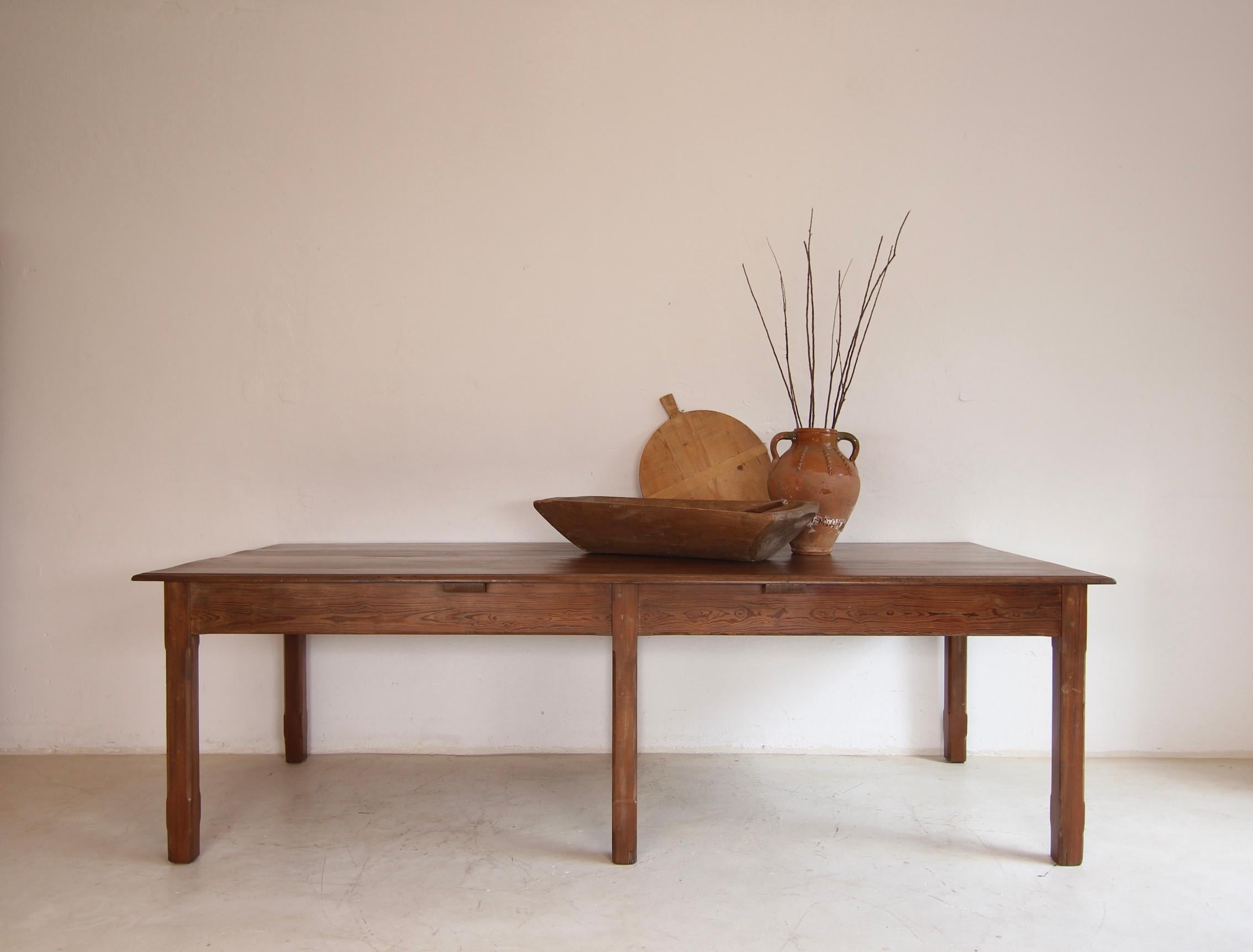 Large table from a shop fitting. Circa 1920/1930. Solidly crafted from pitch pine wood. Ideal as a dining table for 10 people.

Rectangular table frame consisting of 6 chamfered square legs with a frame and a slightly protruding profiled top all
