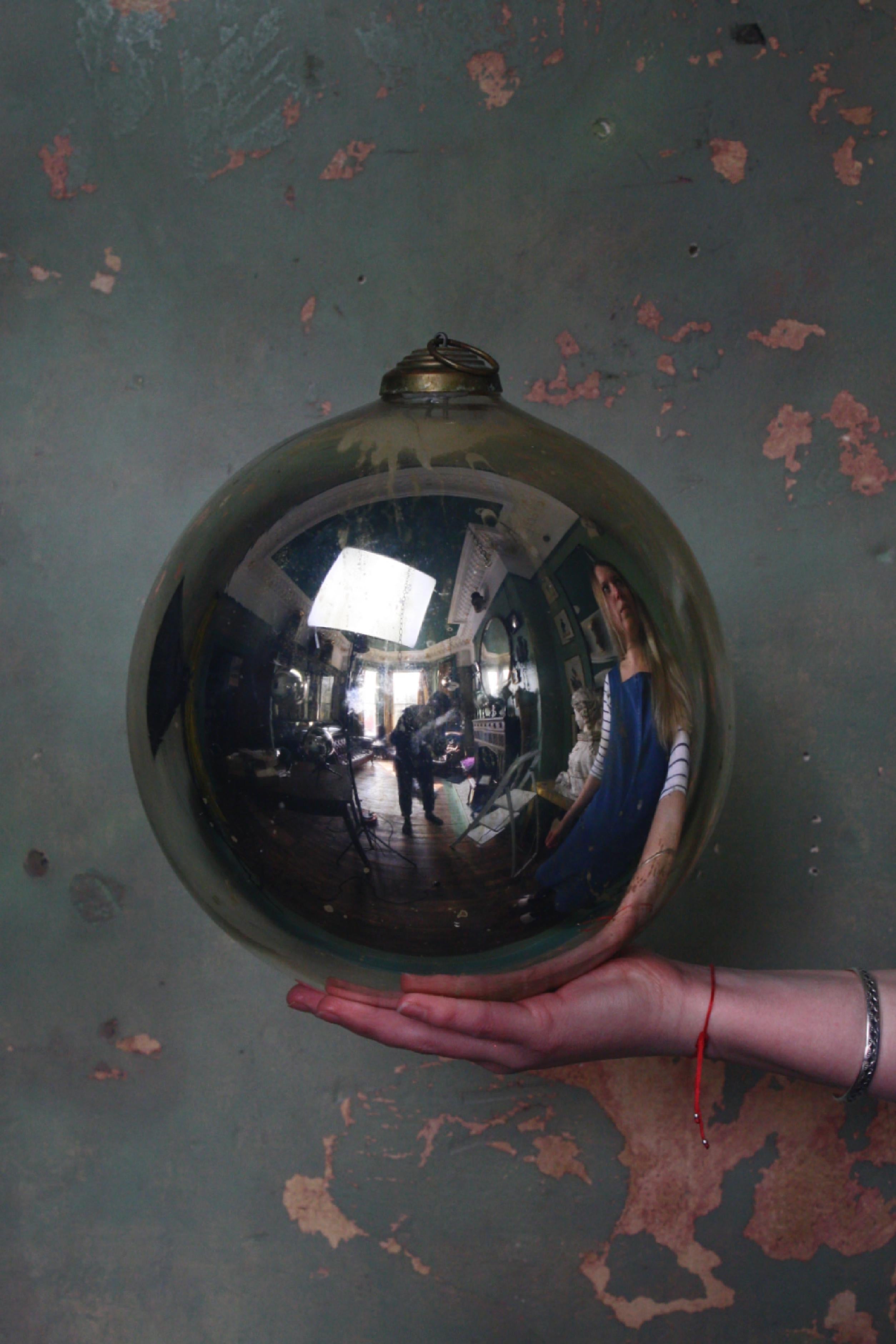 A large early 20th century ball, with age related pitting and oxidization with a pressed brass gallery, approximate measurements 26cm in diameter, 32cm in drop, 81cm in circumference.