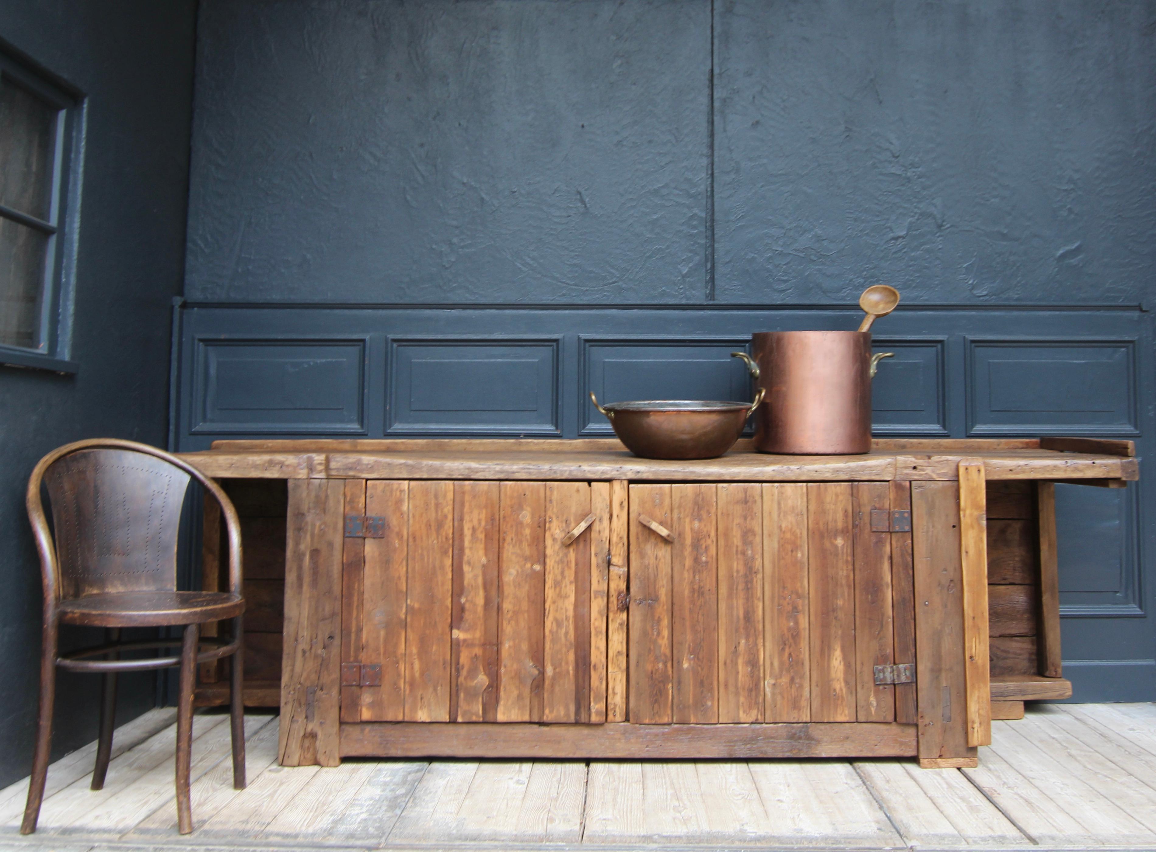 A unique large industrial workbench from the early 20th century made of solid oak and pine wood. Perfect wabi sabi piece with great look. 
 
Half-height two-door cabinet with overhanging top on both sides and a boarded back panel throughout. There
