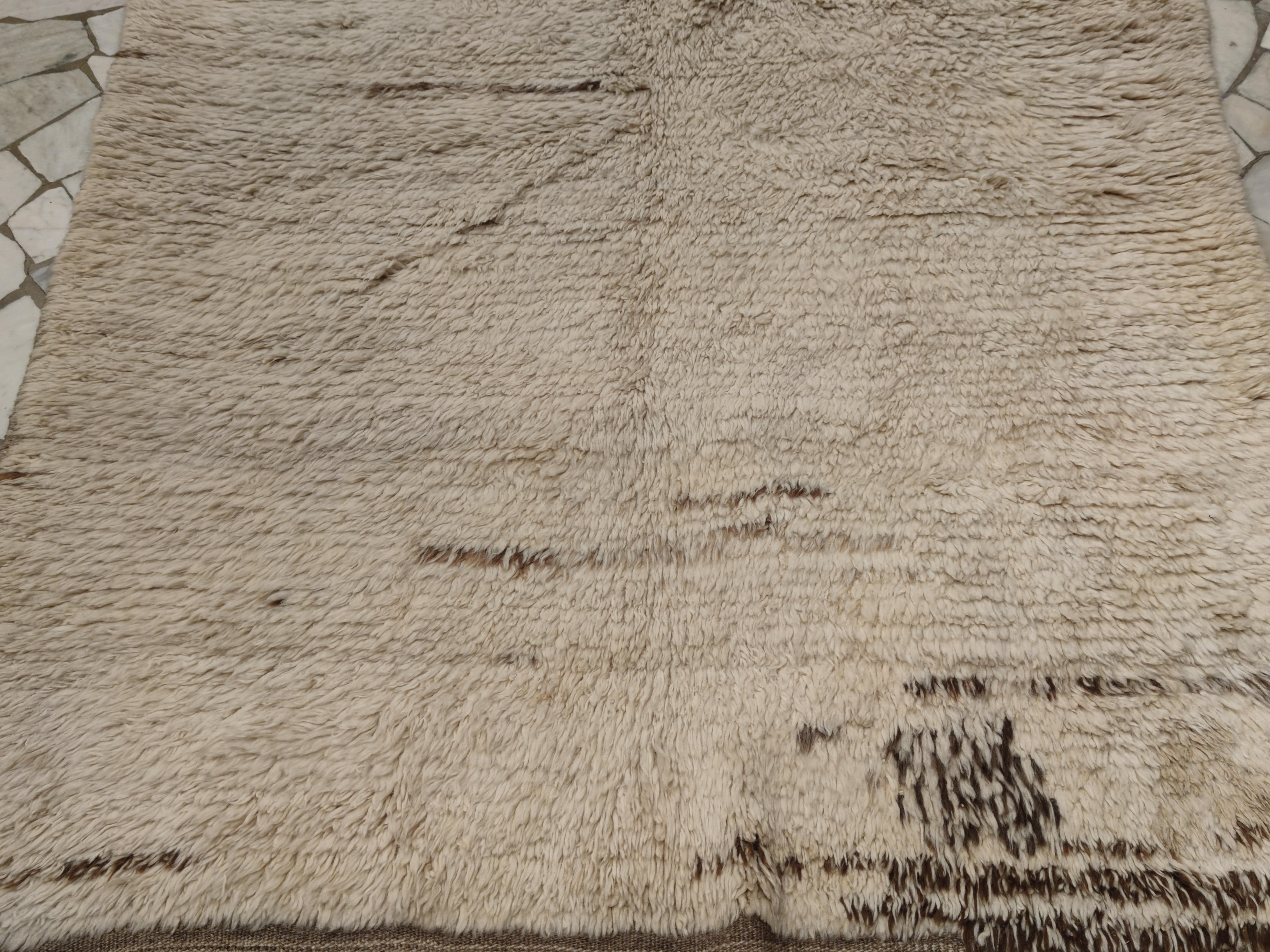 Ein seltenes und relativ frühes Exemplar eines einfarbigen Tulu-Teppichs, der sich durch ein völlig offenes Feld auszeichnet, das durch fast kalligrafische Striche aus naturbrauner Wolle verziert ist. Tulus dieses Typs gehören zu den frühesten