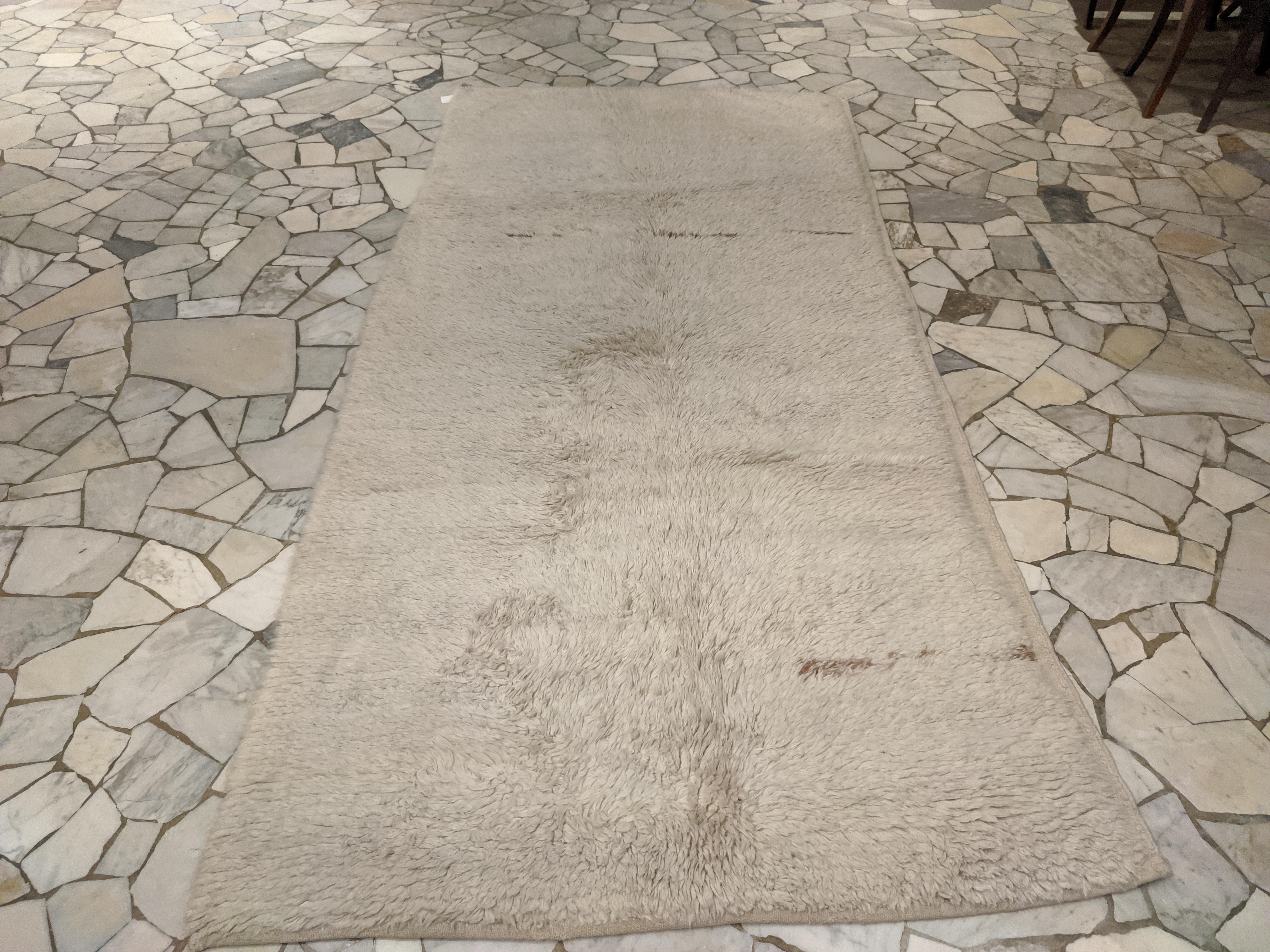 A rare and relatively early example of monochrome Tulu rug, distinguished by a completely open field embellished by almost calligraphic touches of natural brown wool. Tulus of this type are among the earliest extant and are distinguished by a larger