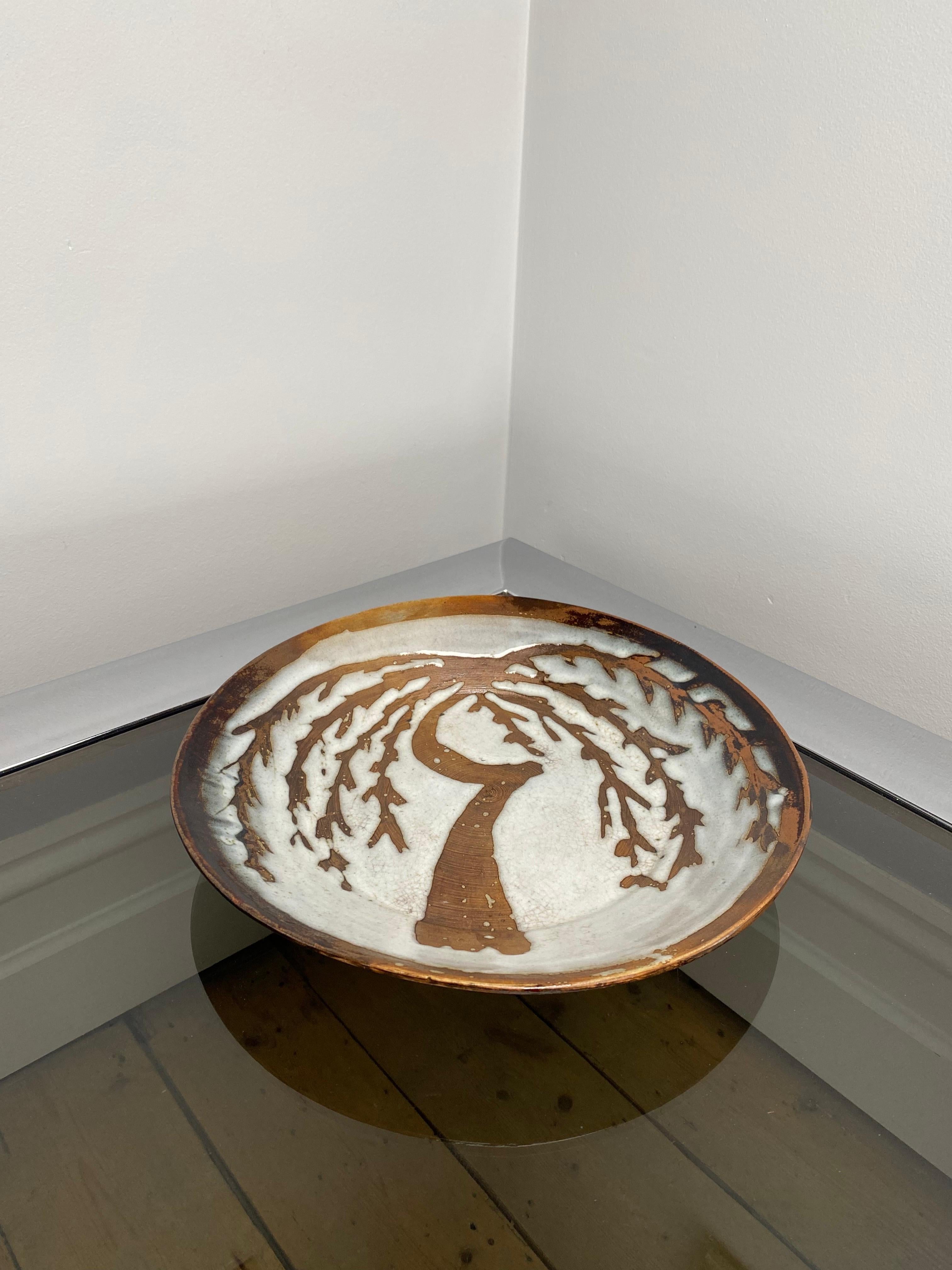 A very attractive bowl, plate or platter, dating to the 1970s. It has all the elements of a David Leach work - the willow motif, high quality earthenware, decorated using the wax resist method. It will make a lovely rustic styling item, to contrast