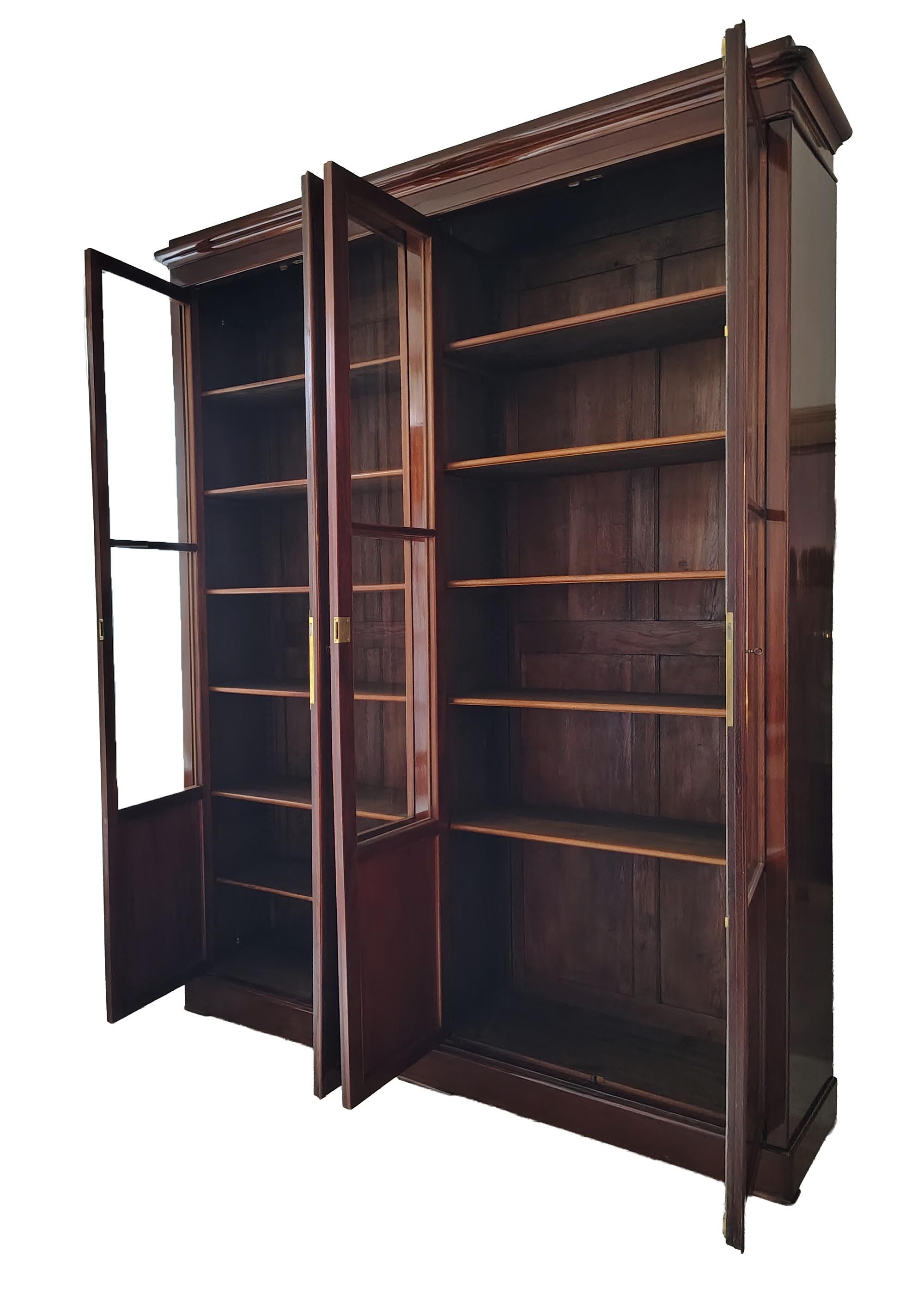 This very large and very impressive early 19th century, Charles X, French bookcase is made of a rich mahogany and makes quite the impression due to its size- 230 cm in width and 280 cm high. This rare biblioteque features four doors with glass-paned