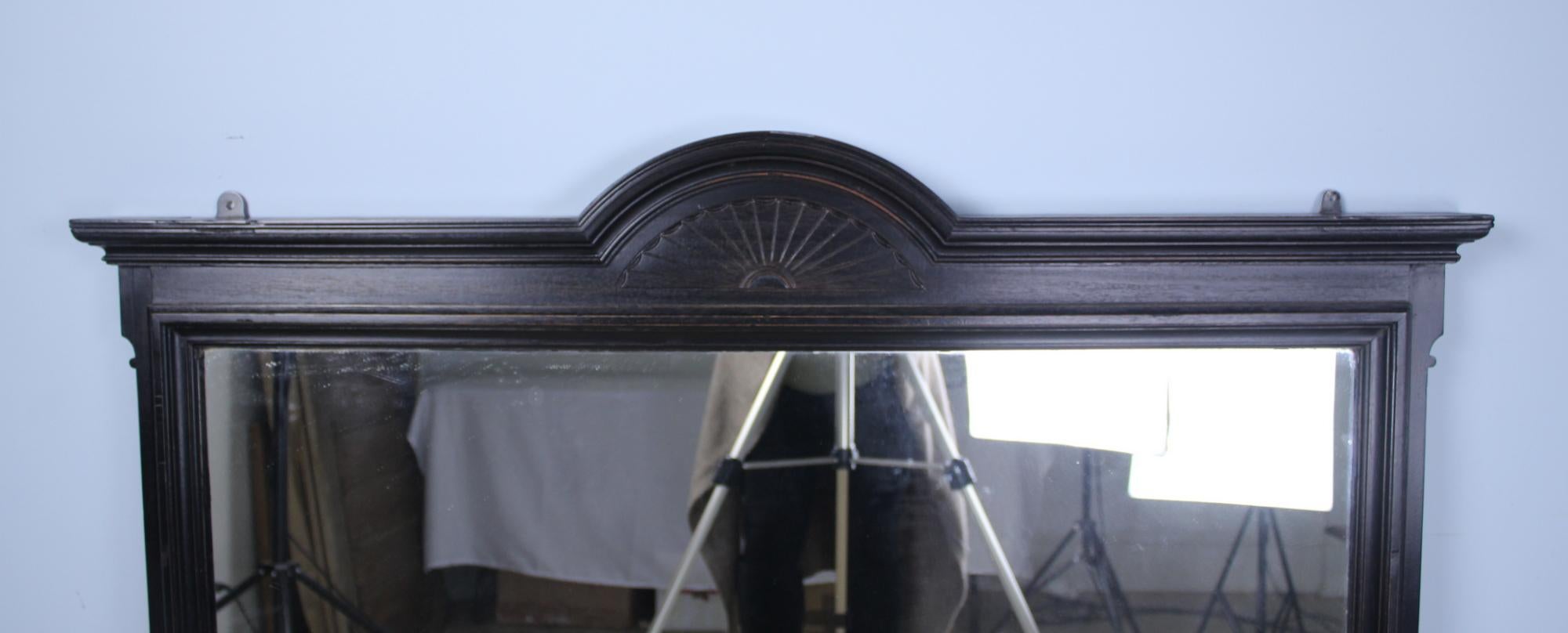 A stunning dark ebonized mirror with original glass. Large and imposing with good period detail. The glass is in good condition with small areas of wear. Brass hooks provide easy hanging. We have another identical mirror, reference #0620-MDJ10B, if