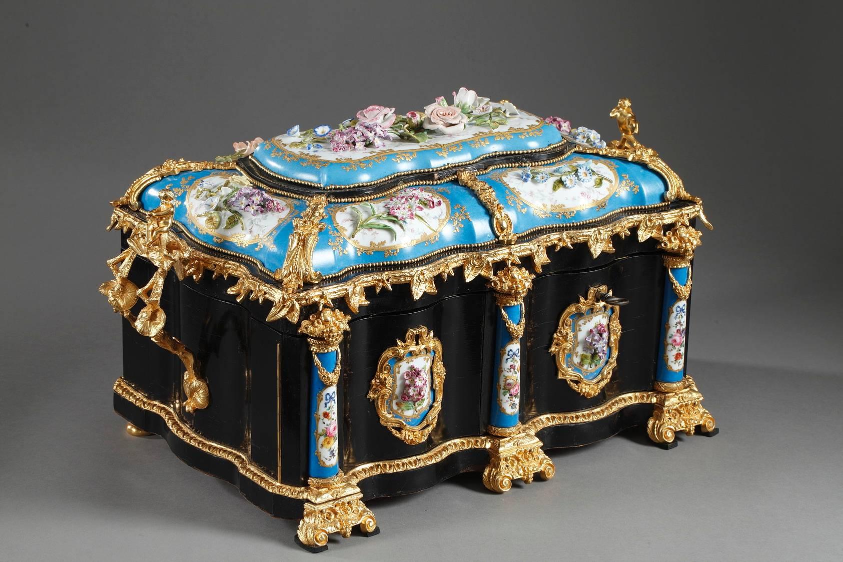 Ebony coffer from the Maison Alphonse Giroux, sumptuously decorated in gilt bronze and porcelain. The lid is richly embellished with rounded porcelain plates that are decorated with multicolored flowers in high relief. The flowers are set in white
