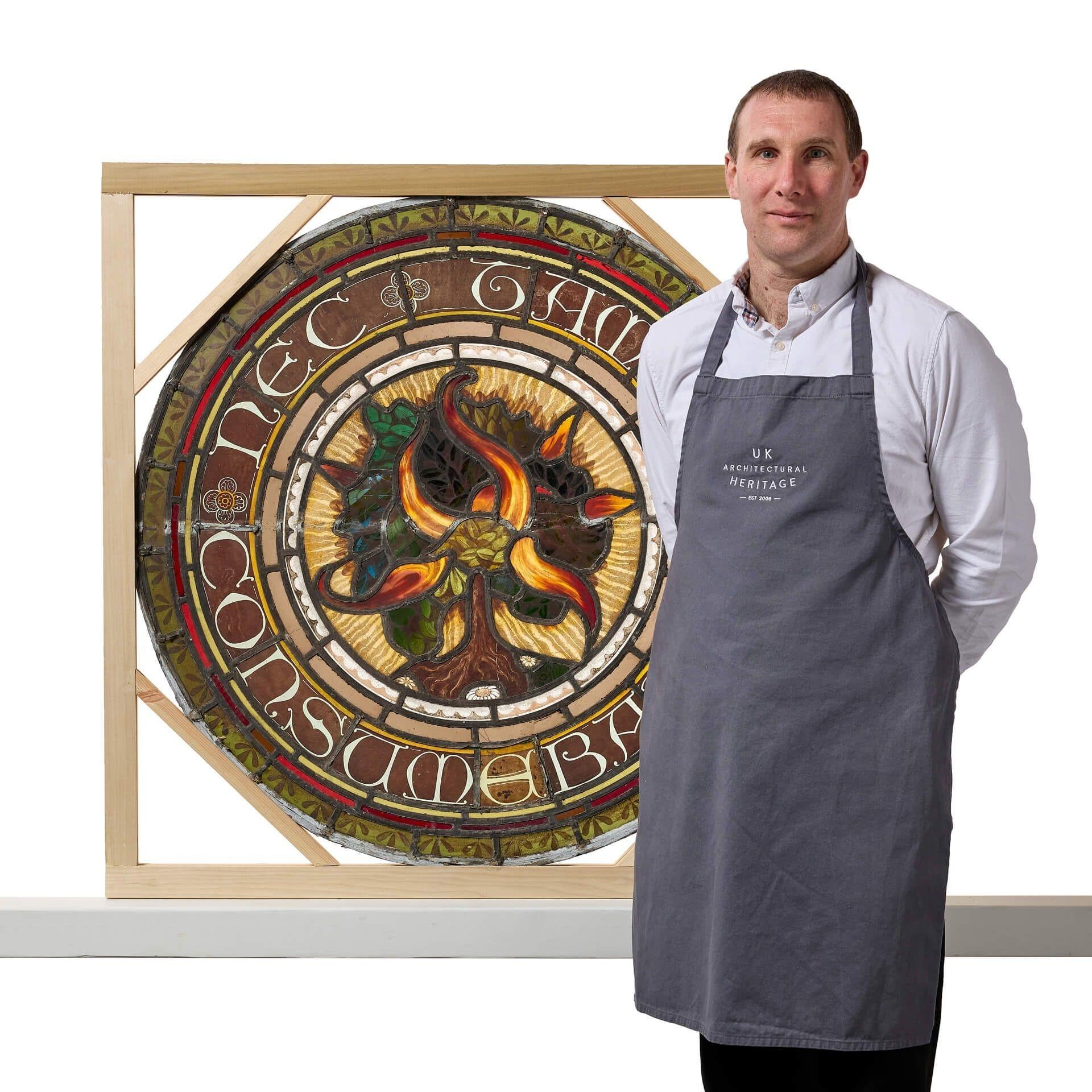 An unrestored large ecclesiastical Scottish stained glass roundel depicting the burning bush. It is handpainted around the perimeter with ‘nec tamen consumebatur’, Latin for ‘yet it was not consumed’; a phrase and symbol famously associated with the
