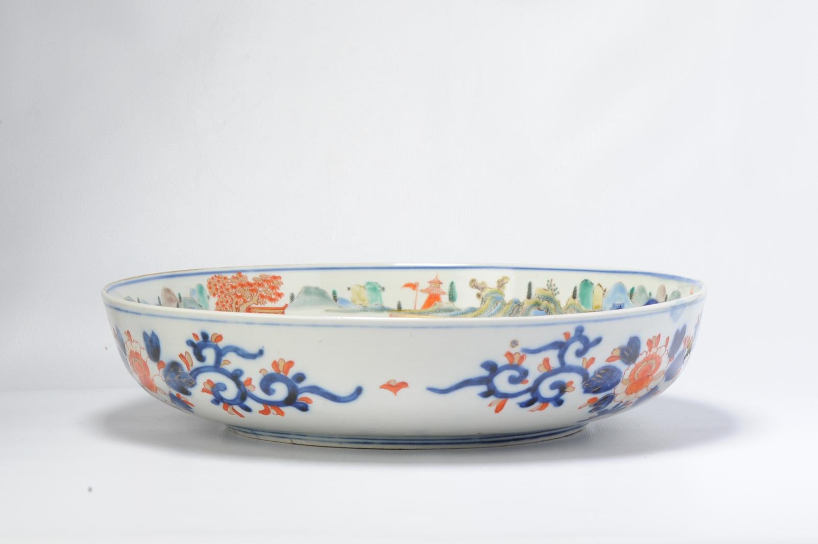 Amazing and large Japanese Basin/Deep serving dish with a polychrome scene of a landscape in the border and part of the centre. Central a pagode is painted on waves with 3 figures standing/walking besides it. Absolutely astonishing piece. Blue and