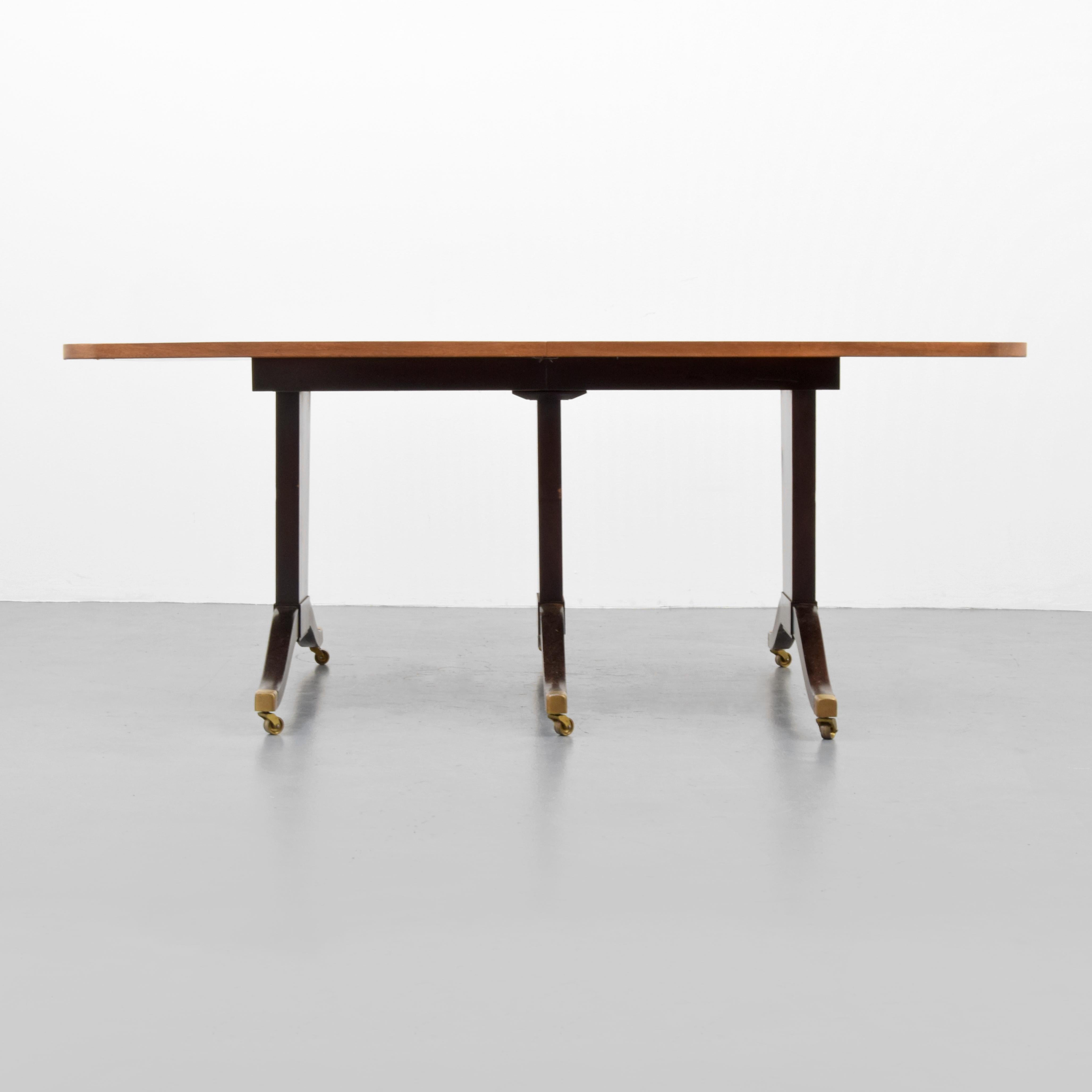 Wheeled dining table with two leaves by Edward Wormley for Dunbar.

Markings: Remnants of Dunbar label.
 
