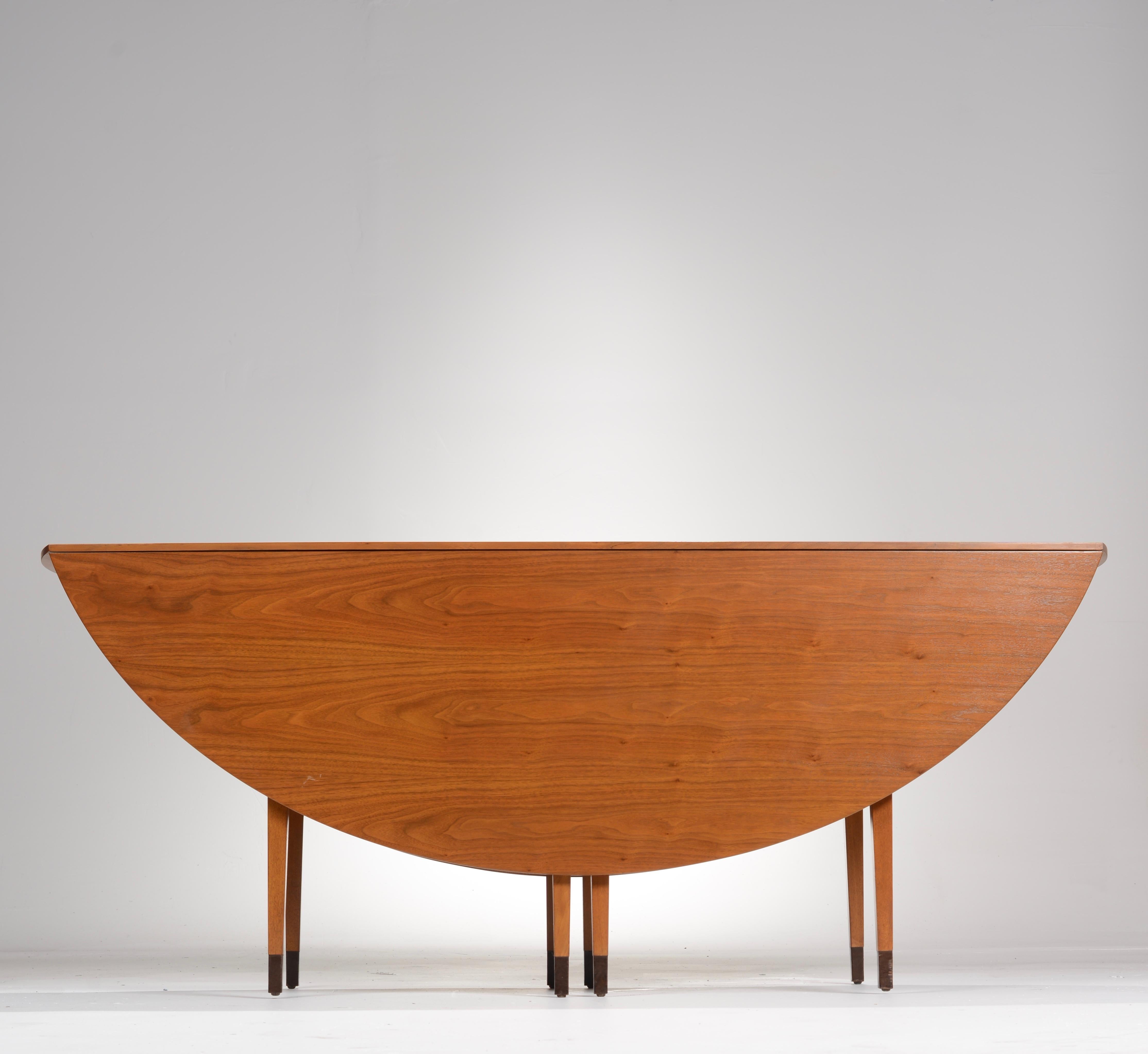 Edward Wormley for Dunbar walnut oval drop-leaf dining table. The table has a beautiful bookmatched walnut wood grain. Extends to 72