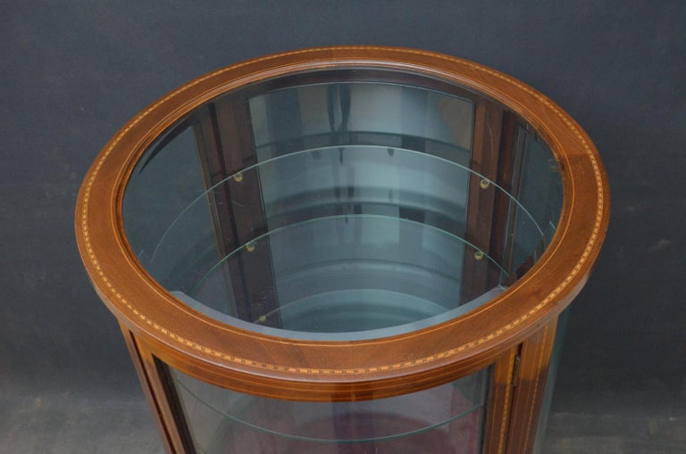 Sn4427, rare and very unusual Edwardian cylindrical display cabinet / vitrine, having original bevelled edge glass to inlaid top, inlaid door fitted with original working lock and a key and 3 glass shelves, standing on tapered legs terminating in